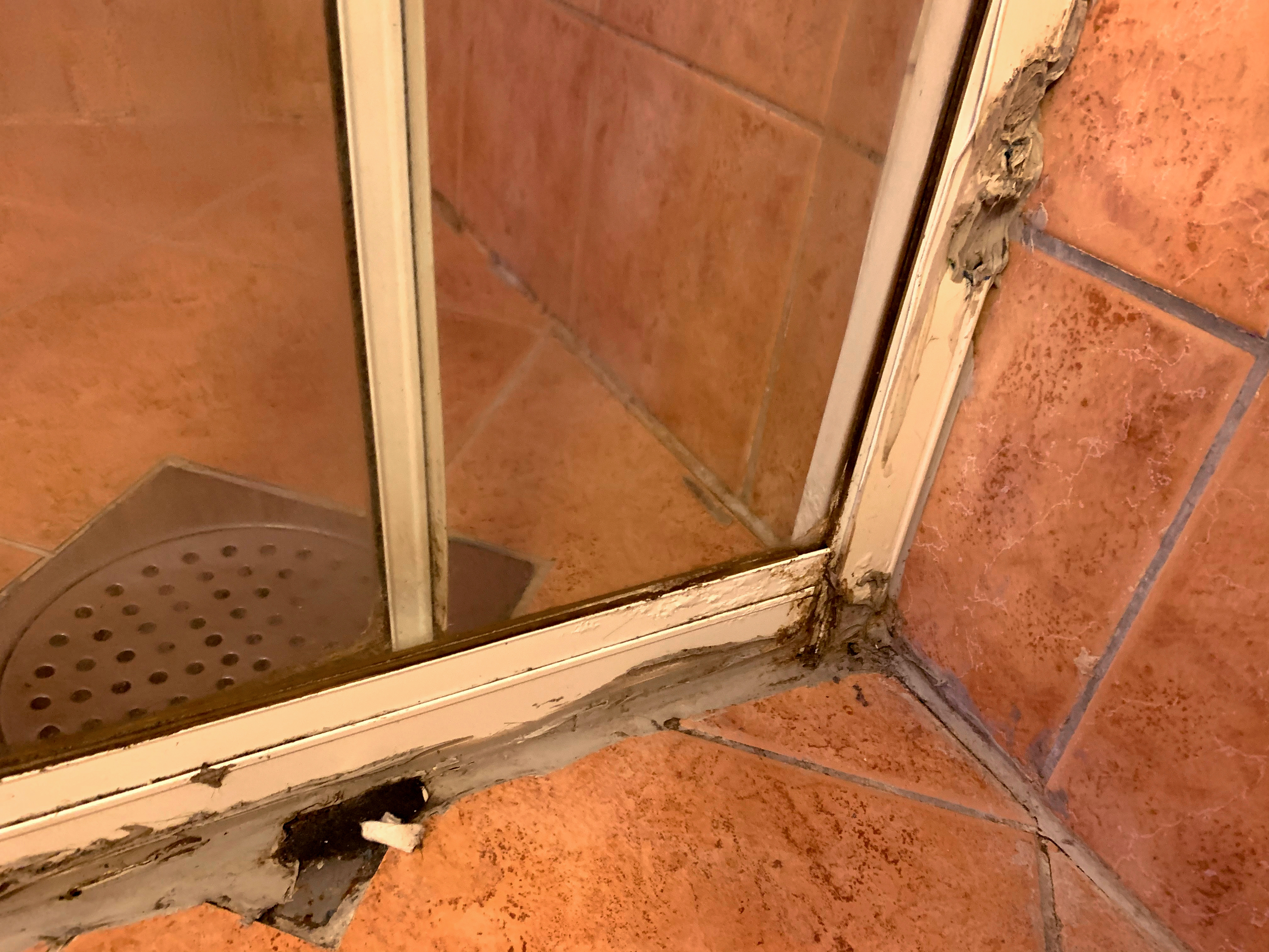 Foto: Av fuktskader og ekle silikonfuger rundt en glassvegg inn til en dusj.