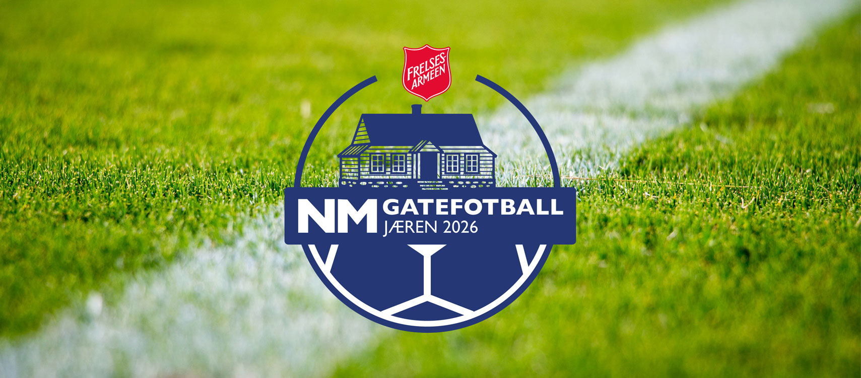 Foto: Av en grønn gressmatte med en hvit strek på siden. Dette er en fotballbane. Midt på ligger en illustrasjon i form av en blå og hvit logo av en fotball med et hus oppå. Helt på toppen er Frelsesarmeens røde logo. Teksten midt på leser: NM Gatefotball Jæren 2026.en fotball