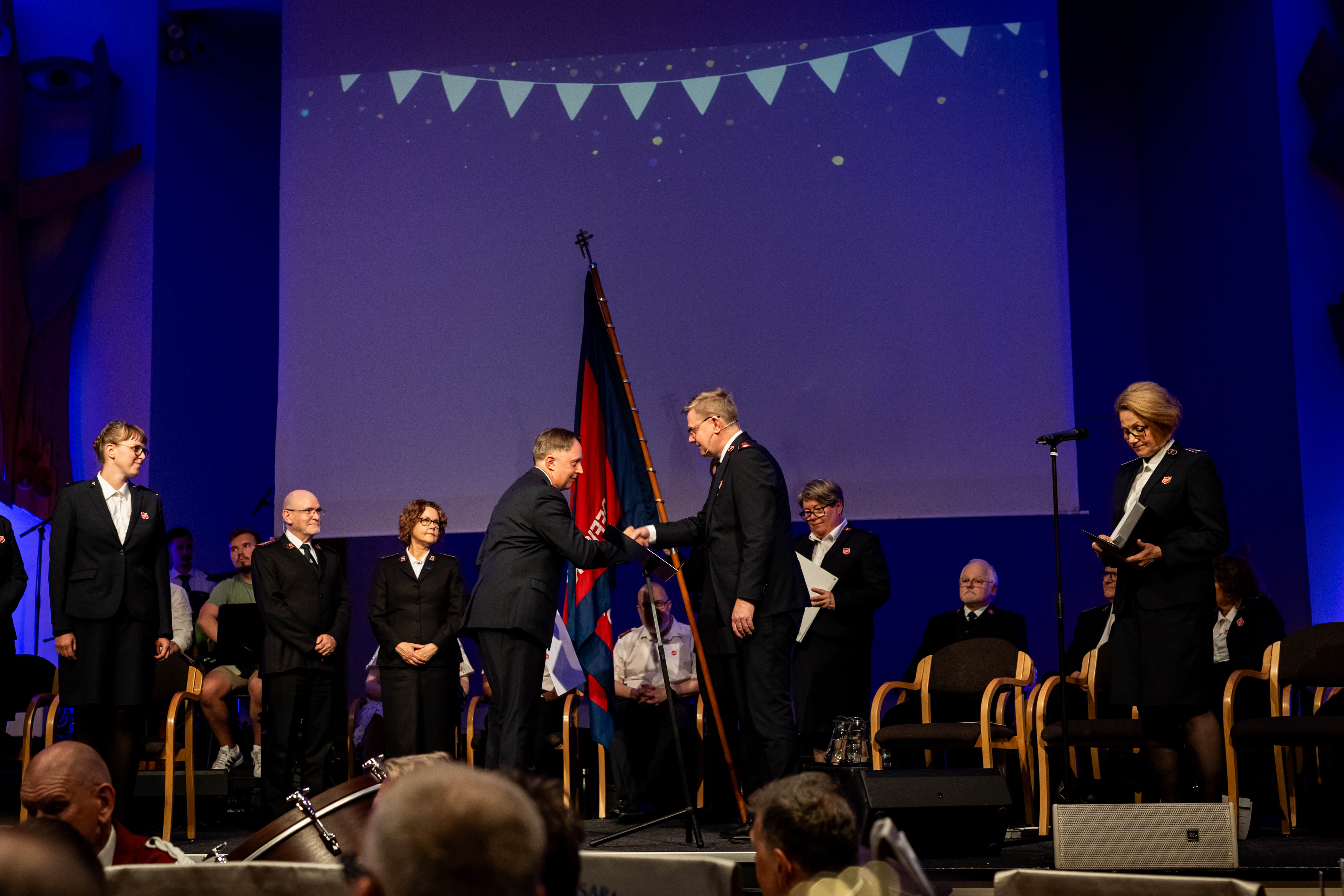 Bilde fra plattformen i Misjonssalen i Oslo der Kommandør Knud David Welander innvier seks nye offiserer i Frelsesarmeen