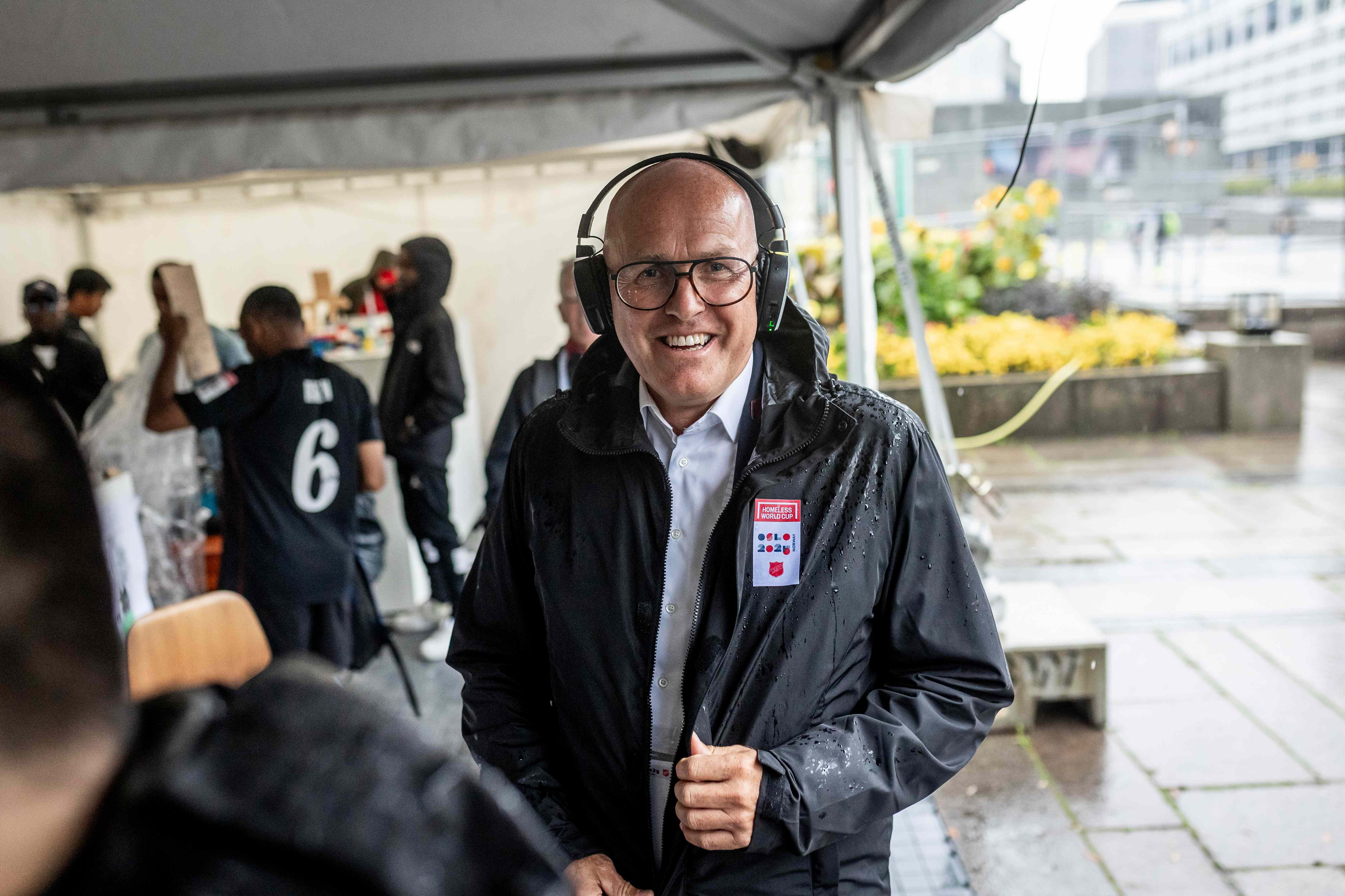 Knut Haugsvær i møtetelt med headset og våt regnjakke på Homeless World Cup