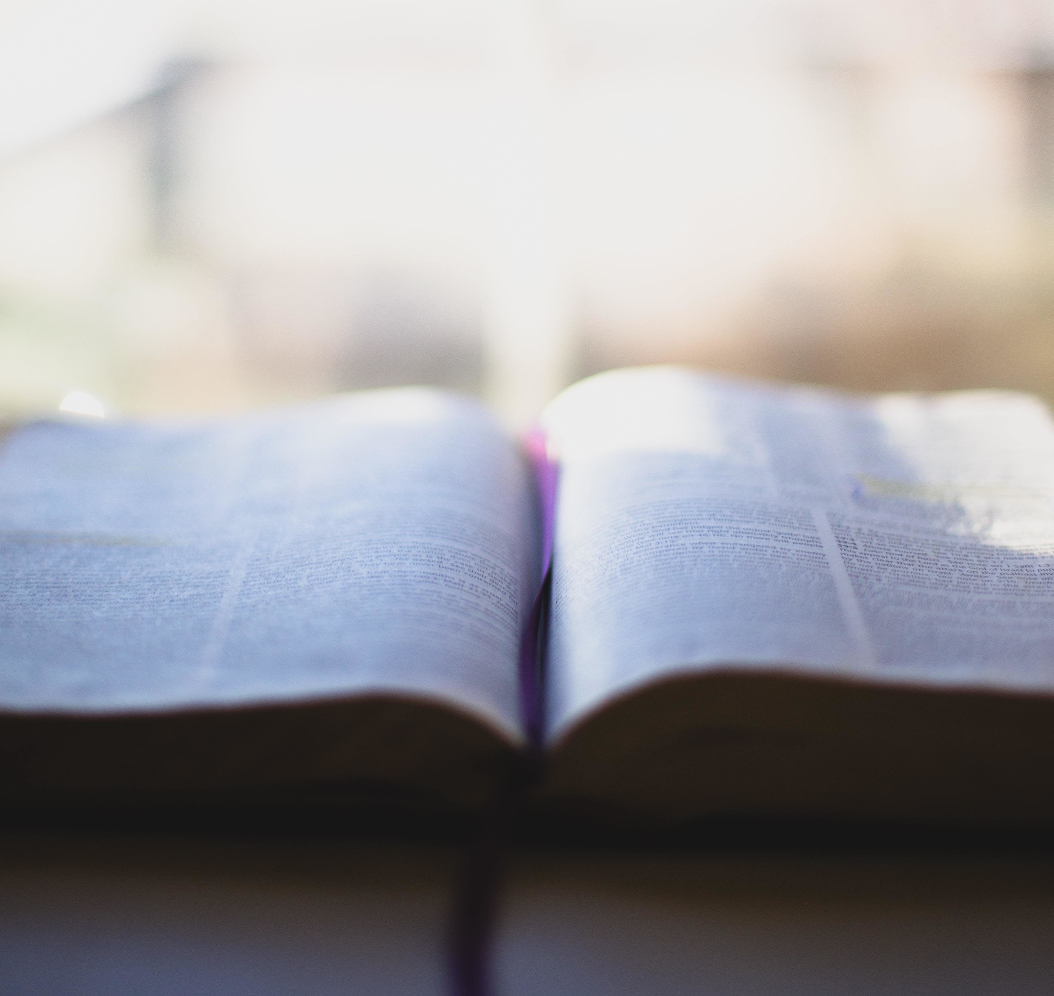 En oppslått bibel med lys, uklar bakgrunn