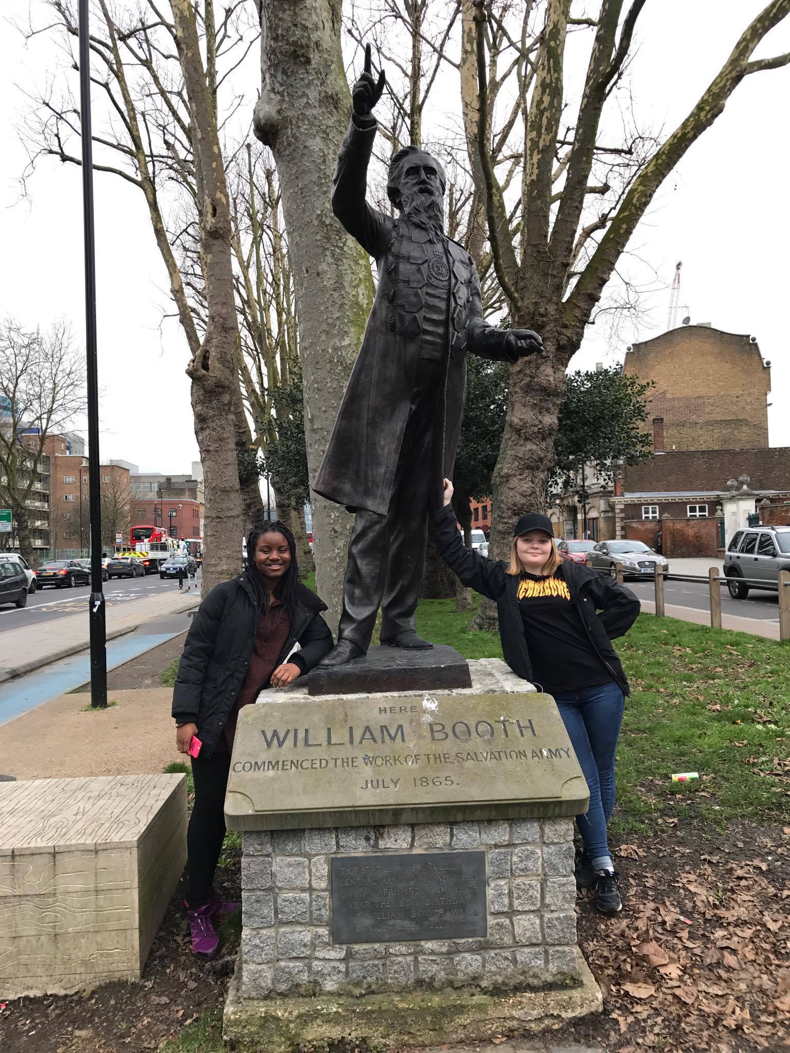 2 ungdommer på statue av William Booth på studietur til London med konfirmantene fra Trondheim.
