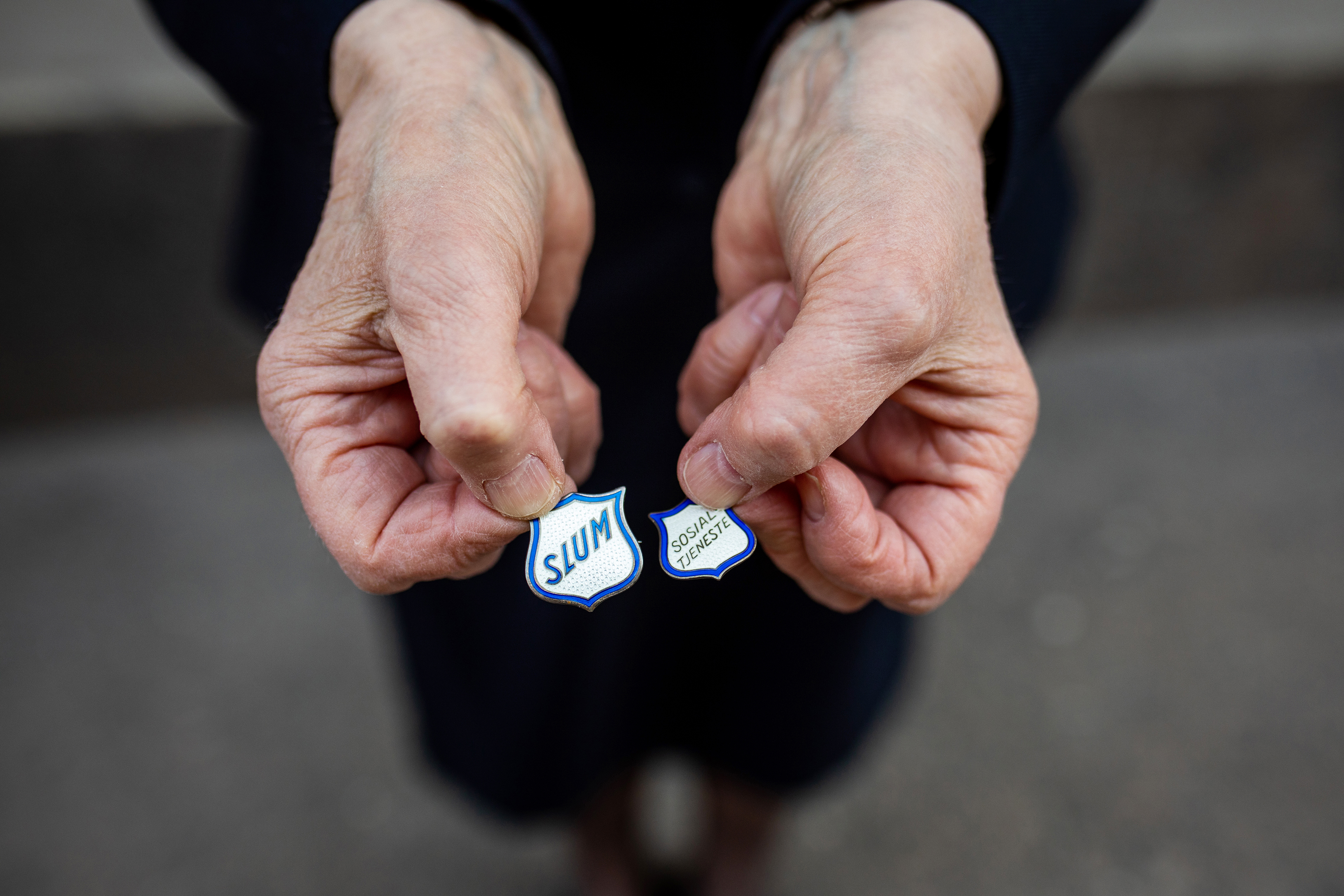 To forskjellige halsnåler begge formet som Frelsesarmeen skjoldet, men i blått og hvitt som matcher slumsøsteruniformen
