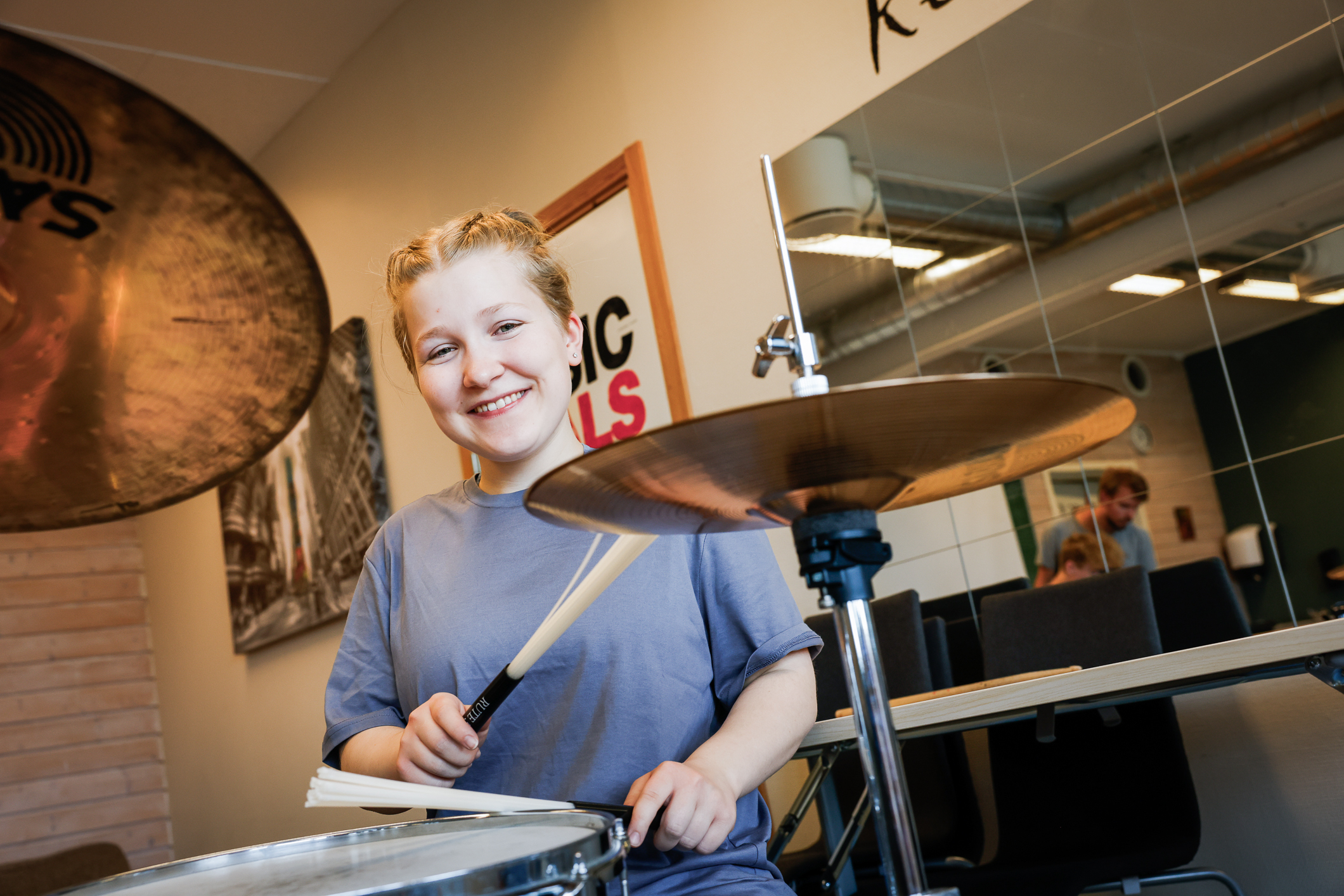 Jente med fletter som spiller slagverk.