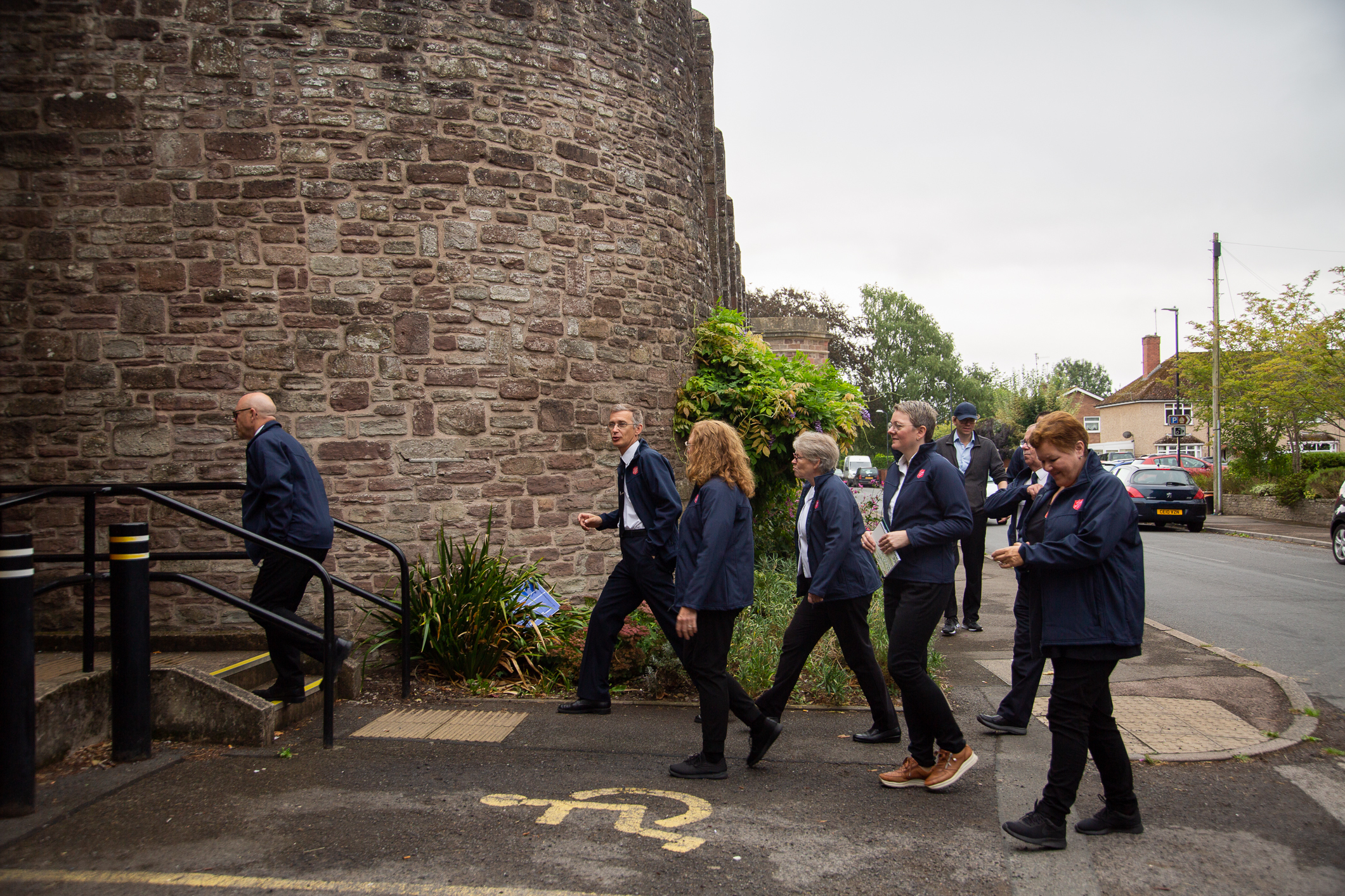 Seks personer fra Frelsesarmeen går inn i en murbygning.