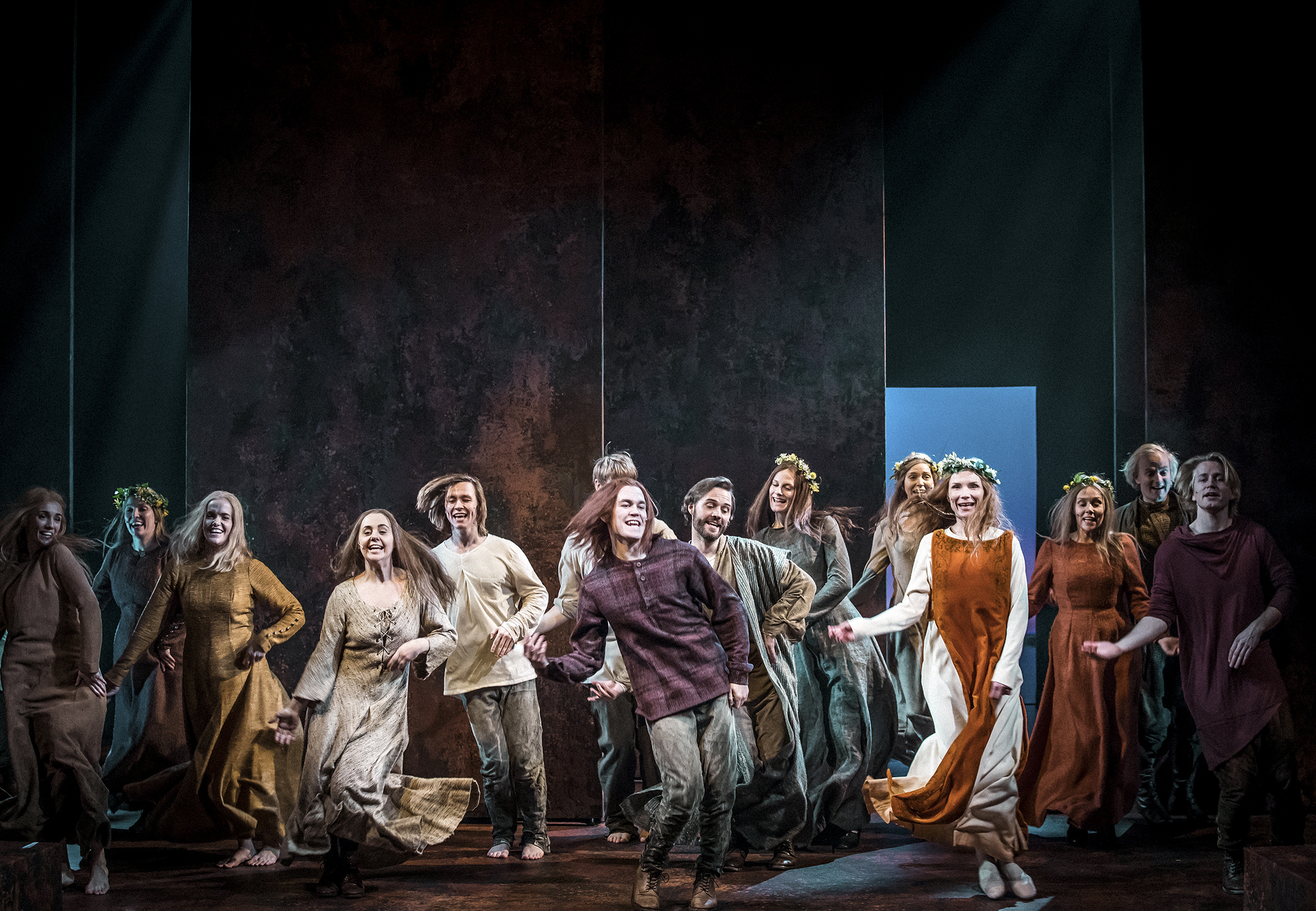 Bildet viser store deler av rollebesetningen i "Kristin Lavransdatter" i dans på en scene.