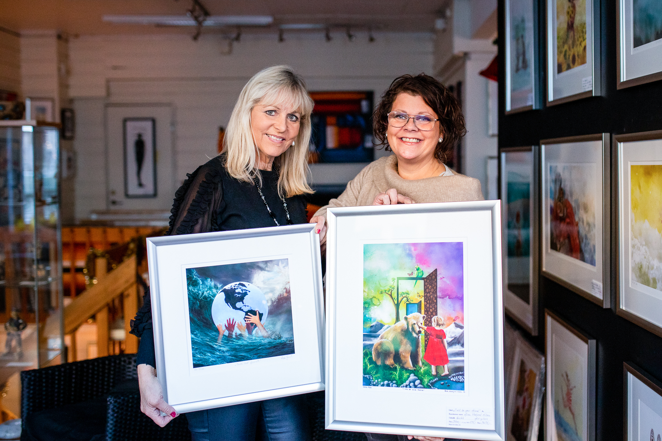 Aina Flatjord-Nilsen og gallerist Åse Juul står inne på Galleriet og viser frem hvert sitt bilde.