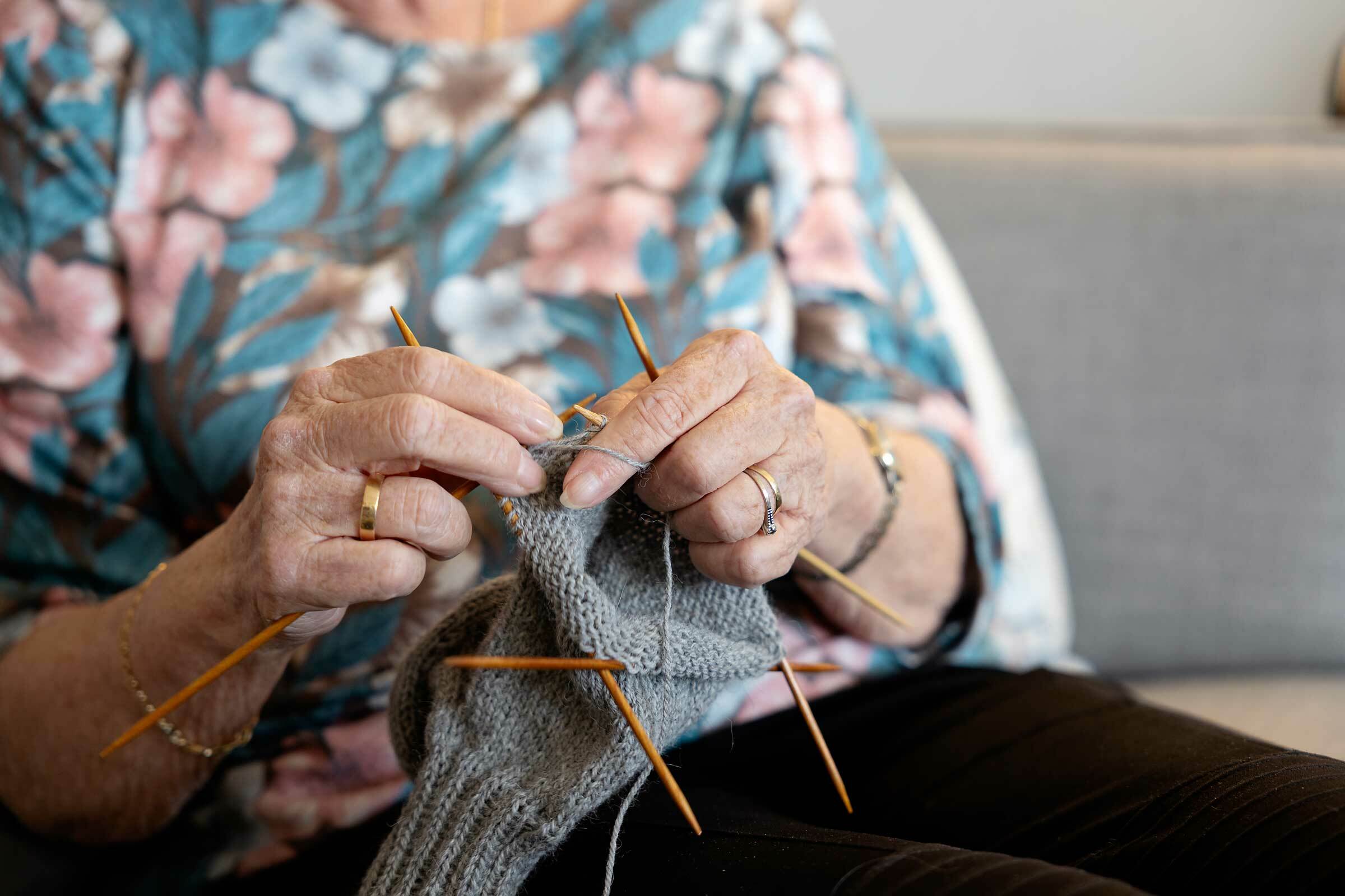 Kvinnehender som strikker med fire pinner