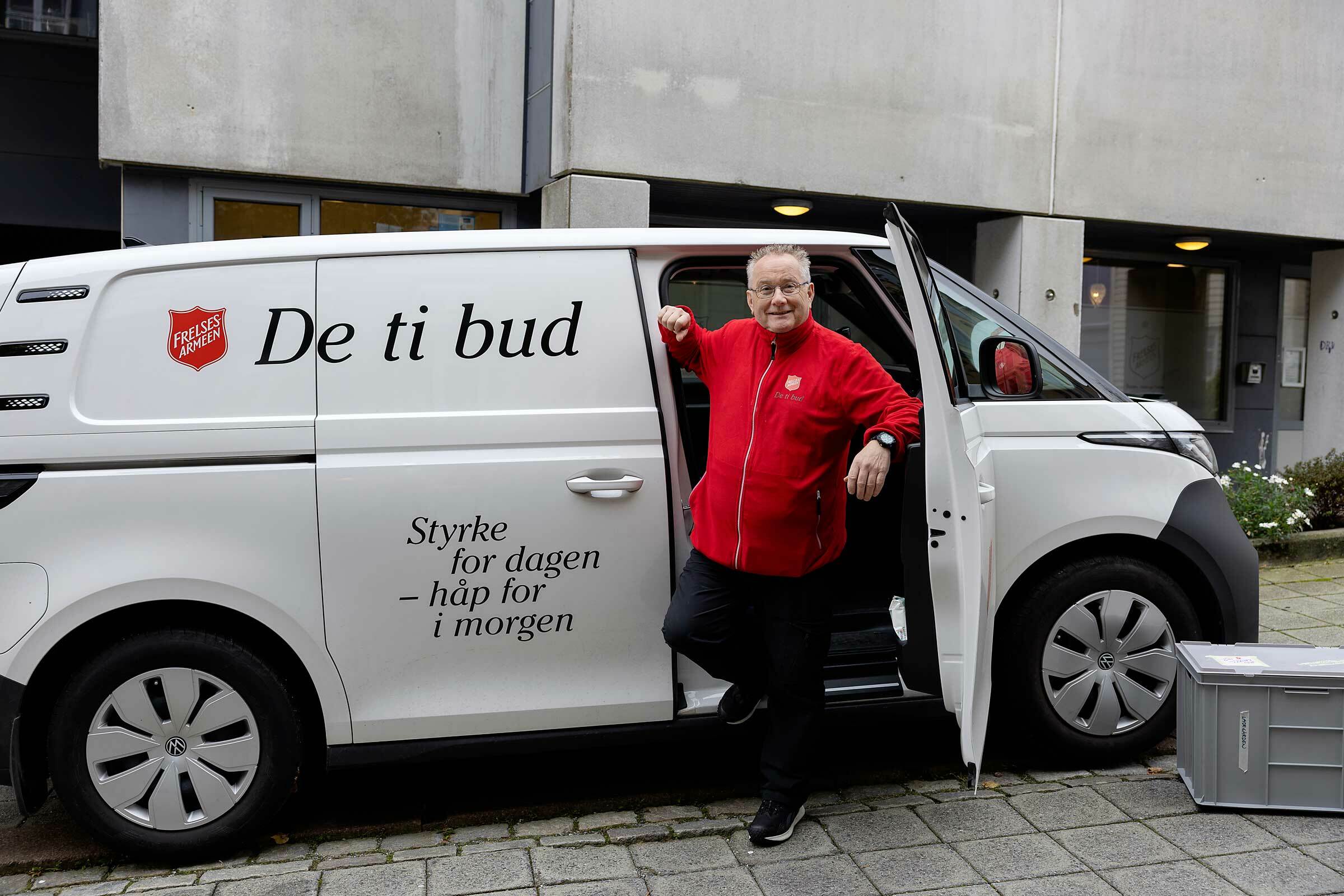 En mann står utenfor en hvit varebil med «De ti bud» i rød skrift på siden.