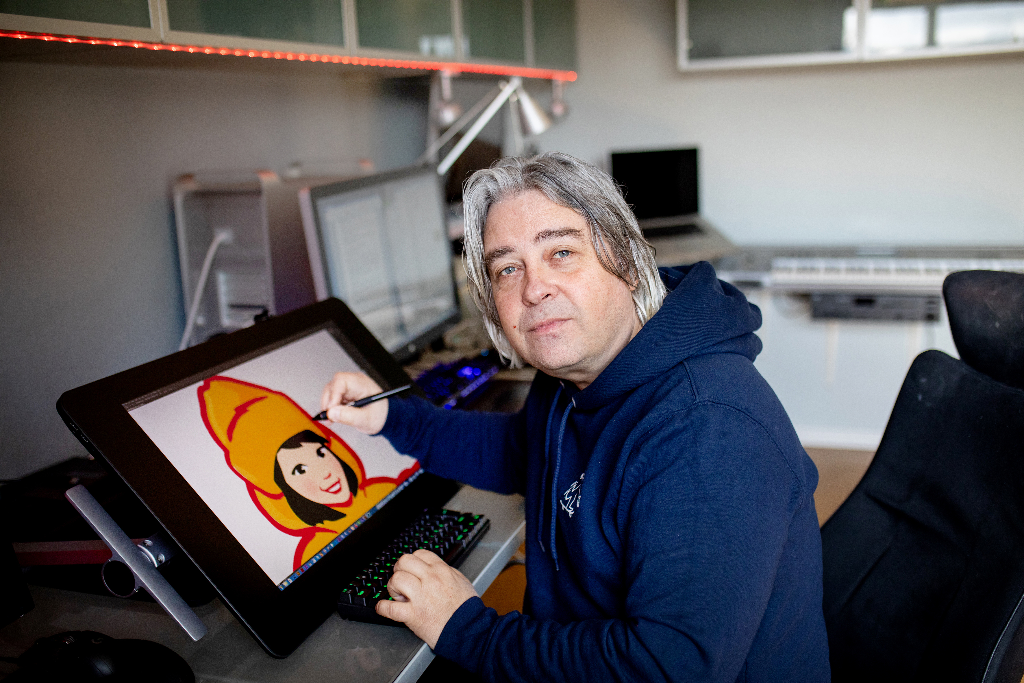 Arild Sæther sitter ved tegnebordet, hvor hav har illustrasjonen til Diplom Is på skjermen.