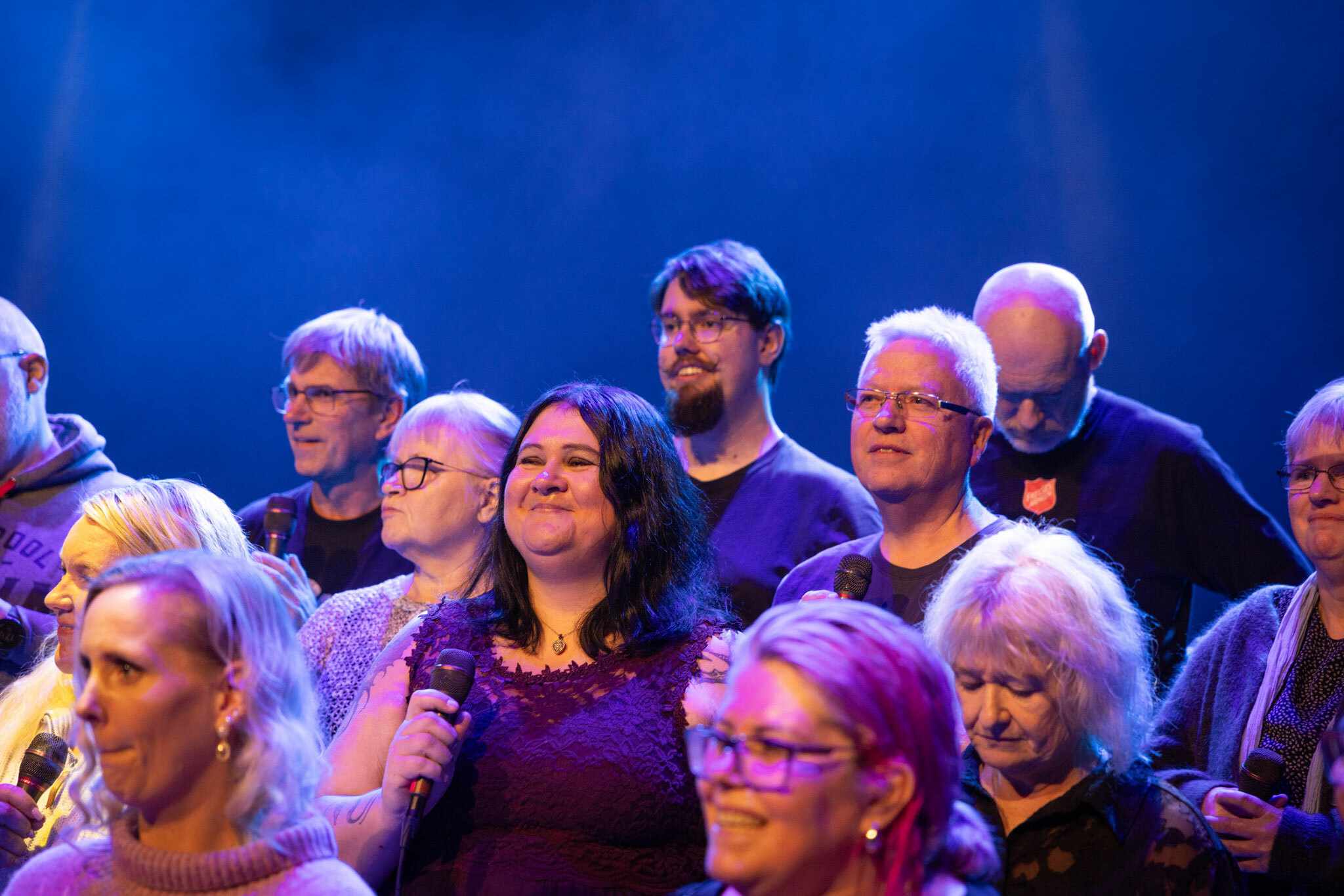 Foto: Et kor står oppstilt i rekker og det er med flest kvinner, men også noen menn.