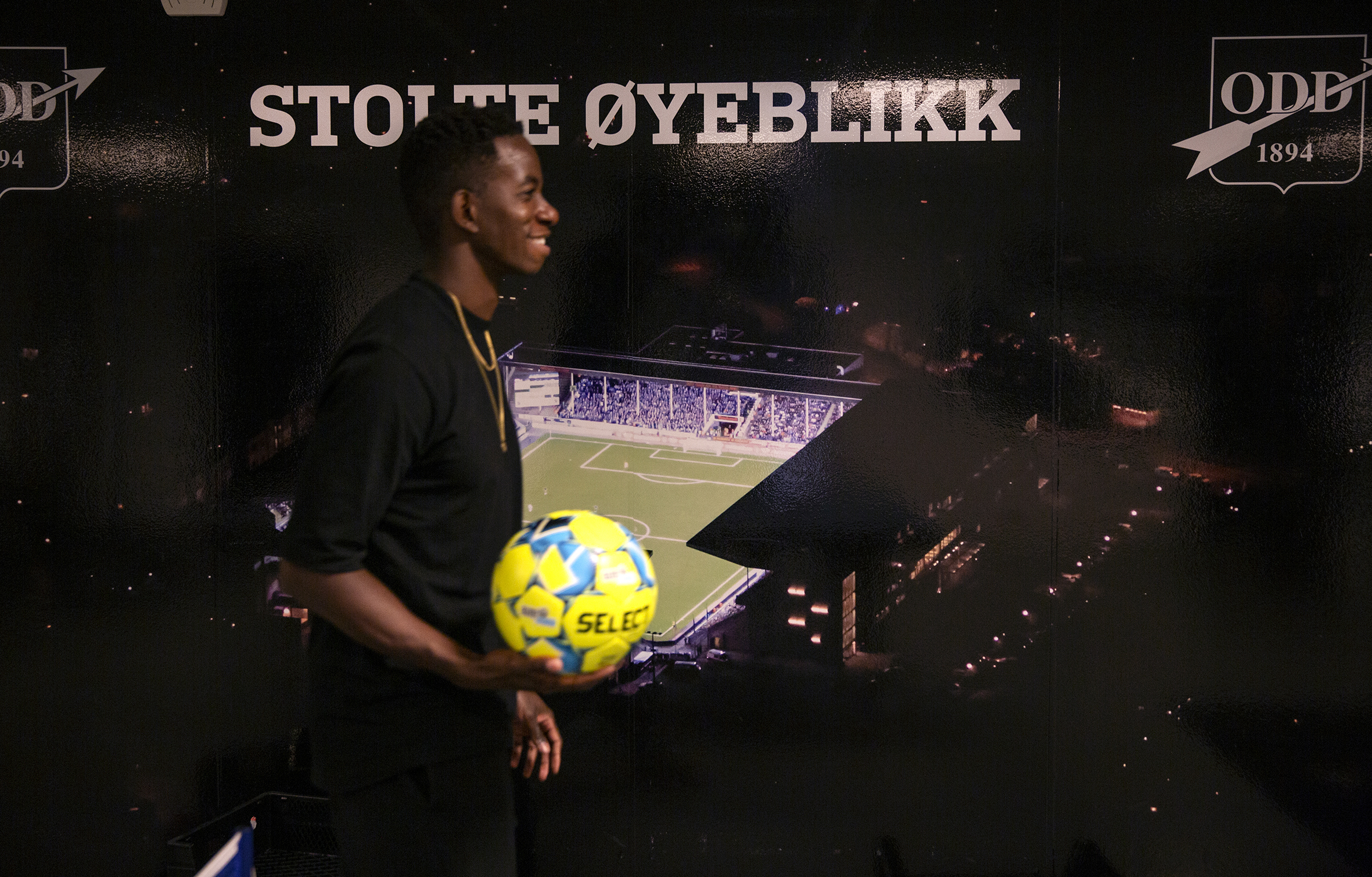 Det første bildet viser Bakenga foran et bilde av en fotballbane og teksten "stolte øyeblikk", det andre viser en hånd som holder en mobiltelefon med tekstmeldinger.