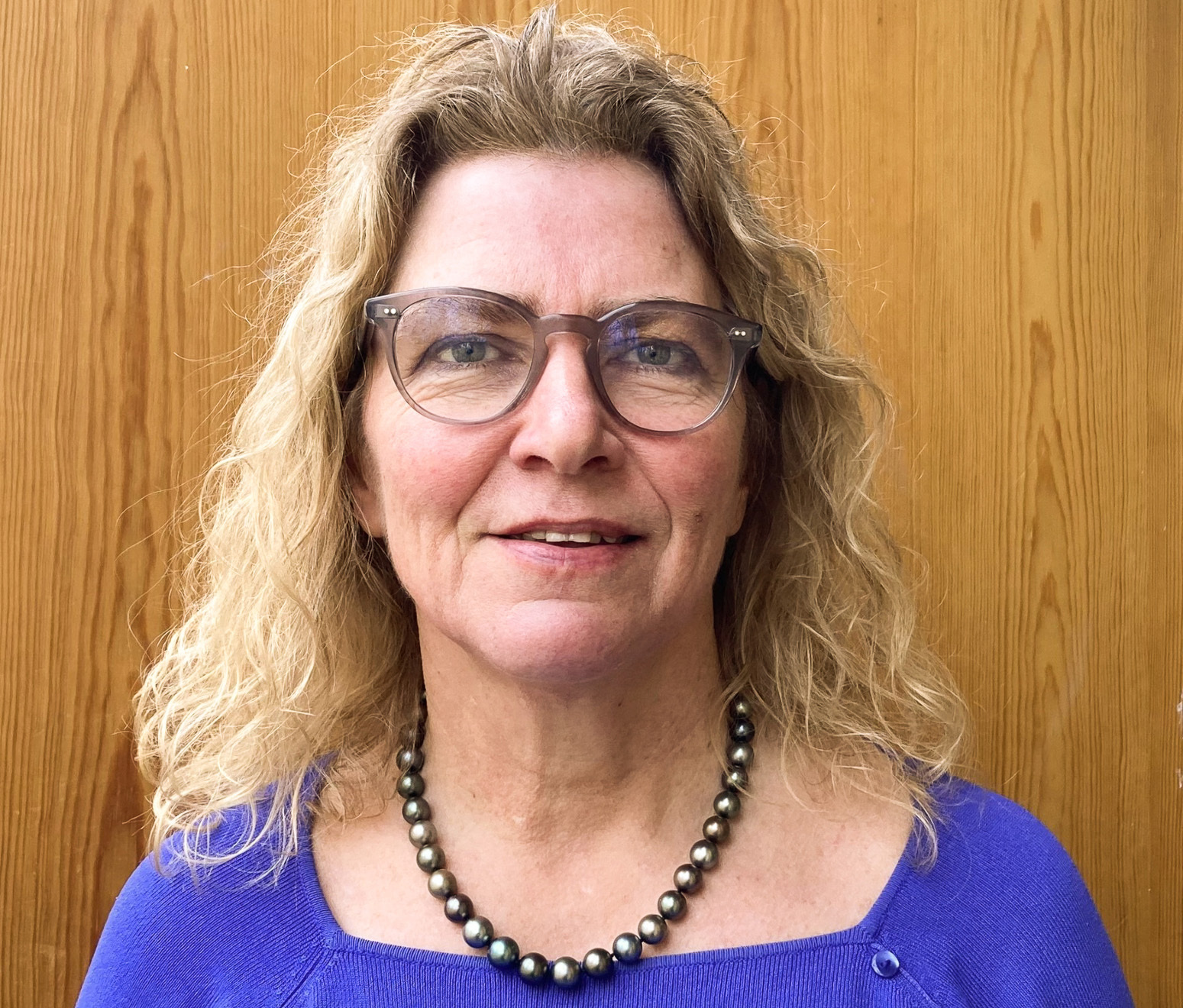 Middelaldrende kvinne med halvlangt lyst hår og briller.