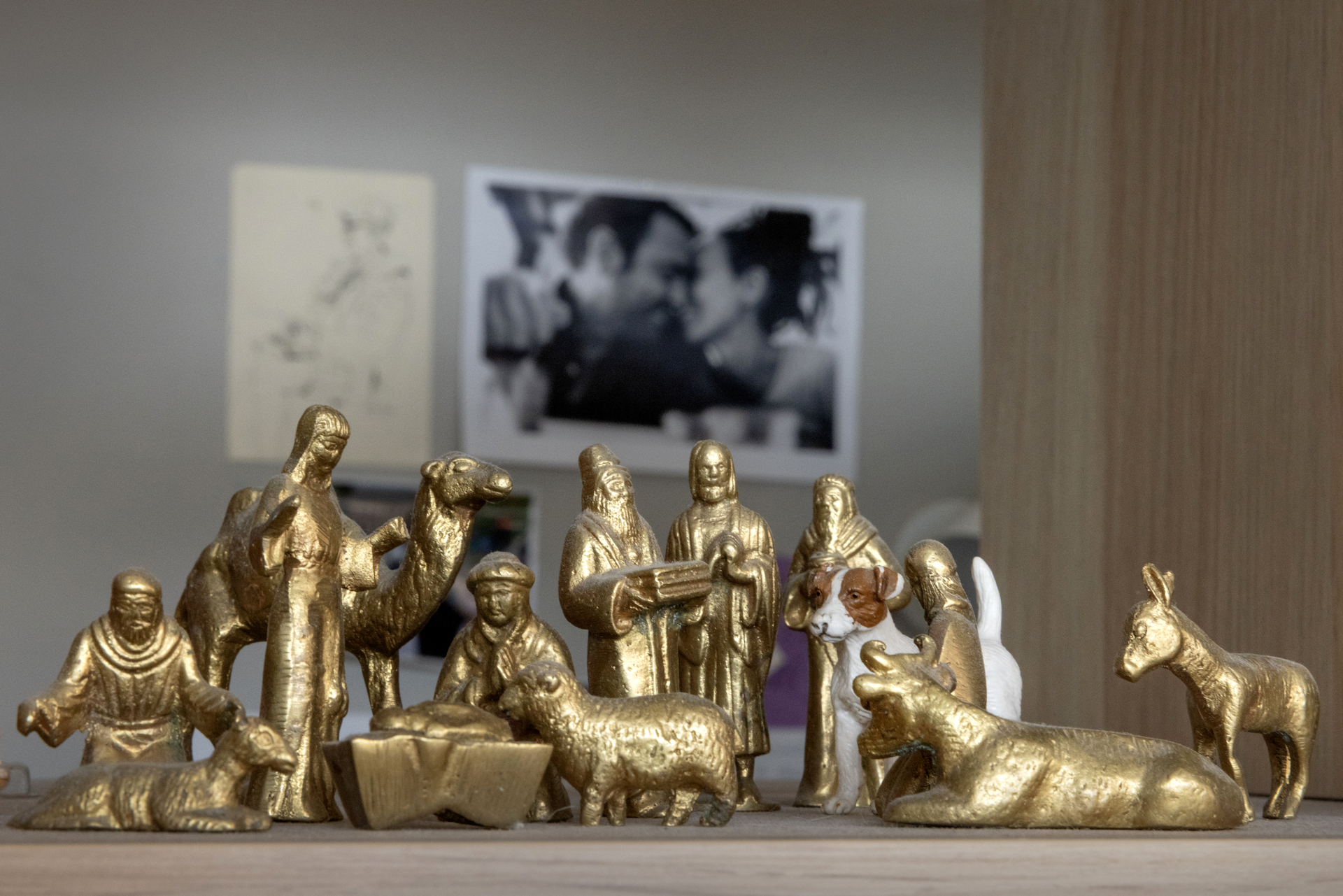 Foto: Julekrybbe i messing der det også er plassert en liten Jack Russel-terrier i hvitt og brunt foran Jesus-barnet. På veggen bak henger et svart-hvitt bilde av et par som kysser.