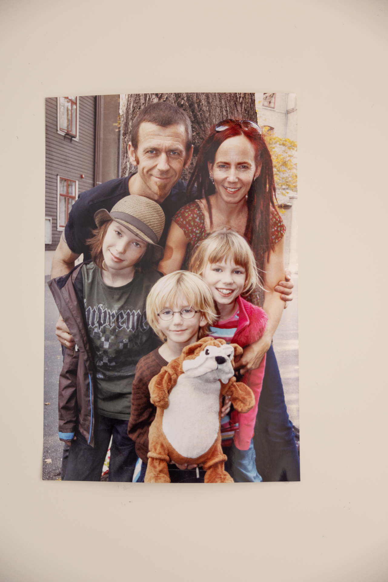 Foto: Av et familefotografi som henger rett på veggen uten ramme.