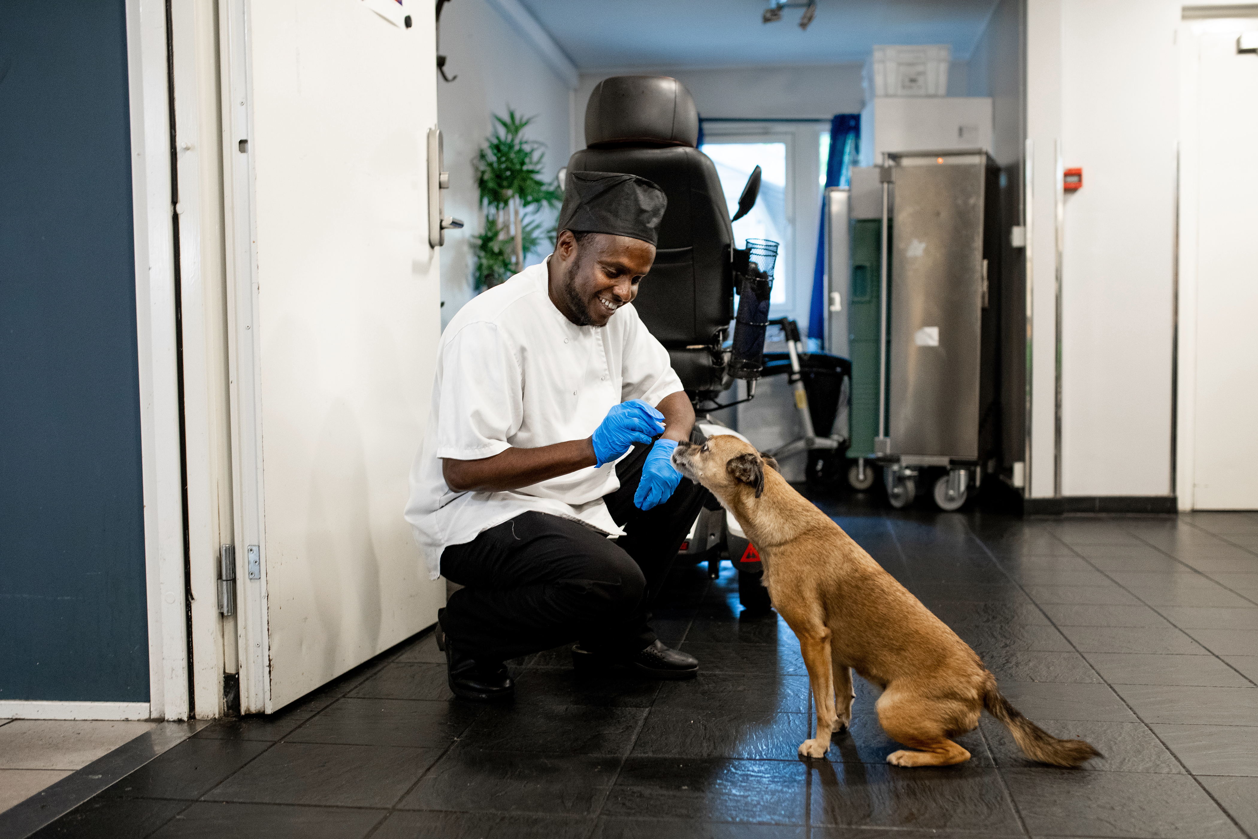 Bashir har fått jobb på kjøkkenet på Heimen, her er han sammen med hunden til sosialfaglig leder.