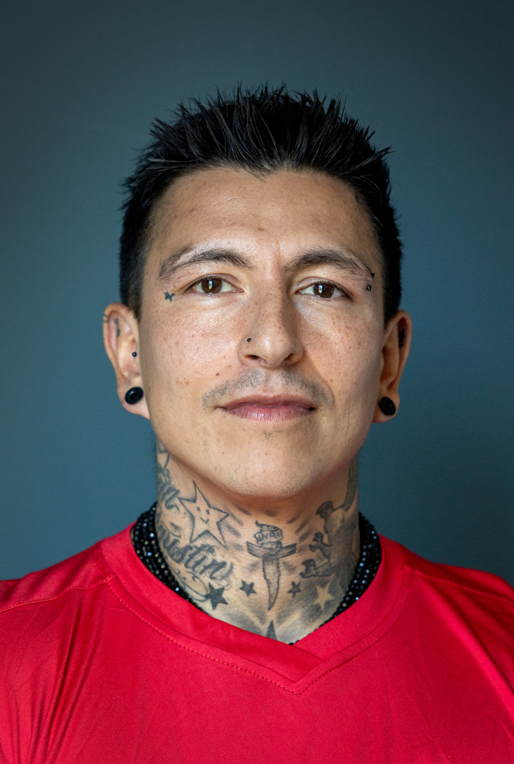 Foto: Mann med gylle hun og kort, svart hår ser alvorlig ut. Han har på seg en rød fotballtrøye.