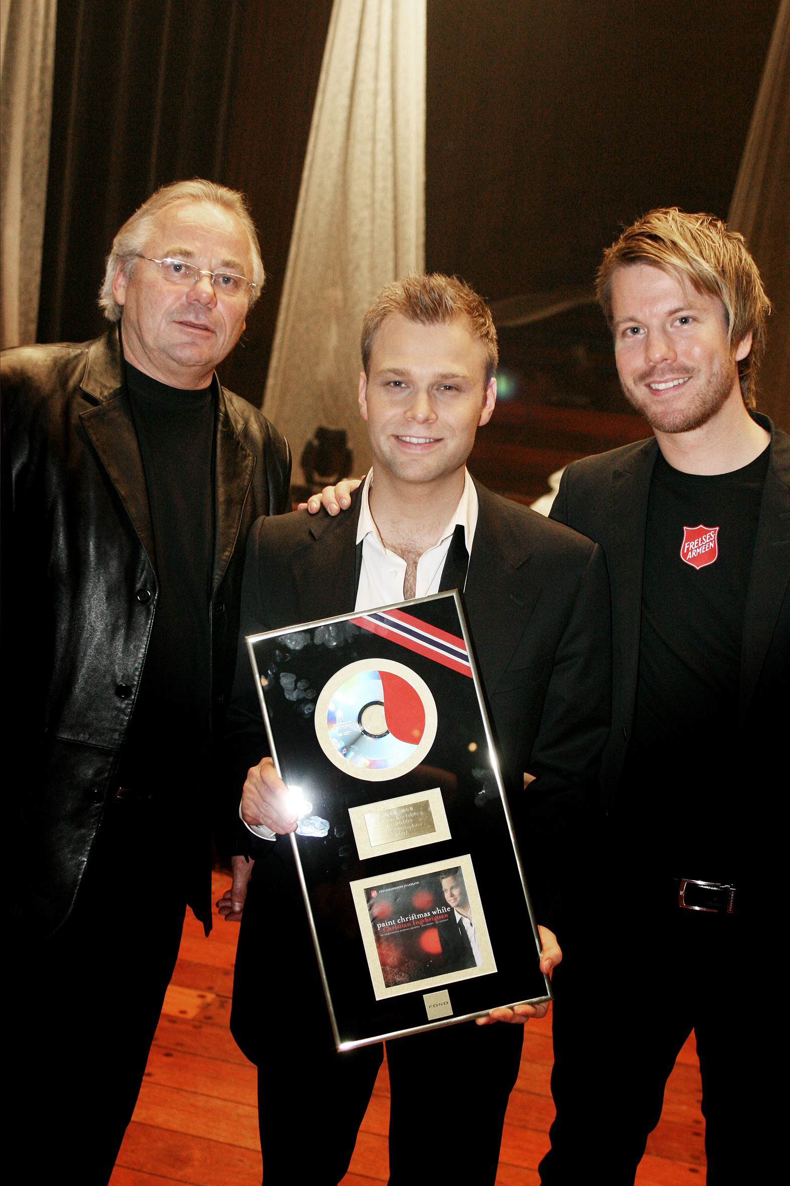Christian Ingebrigtsen med gullplateplakett sammen med representant for Frelsearmeen og plateselskap