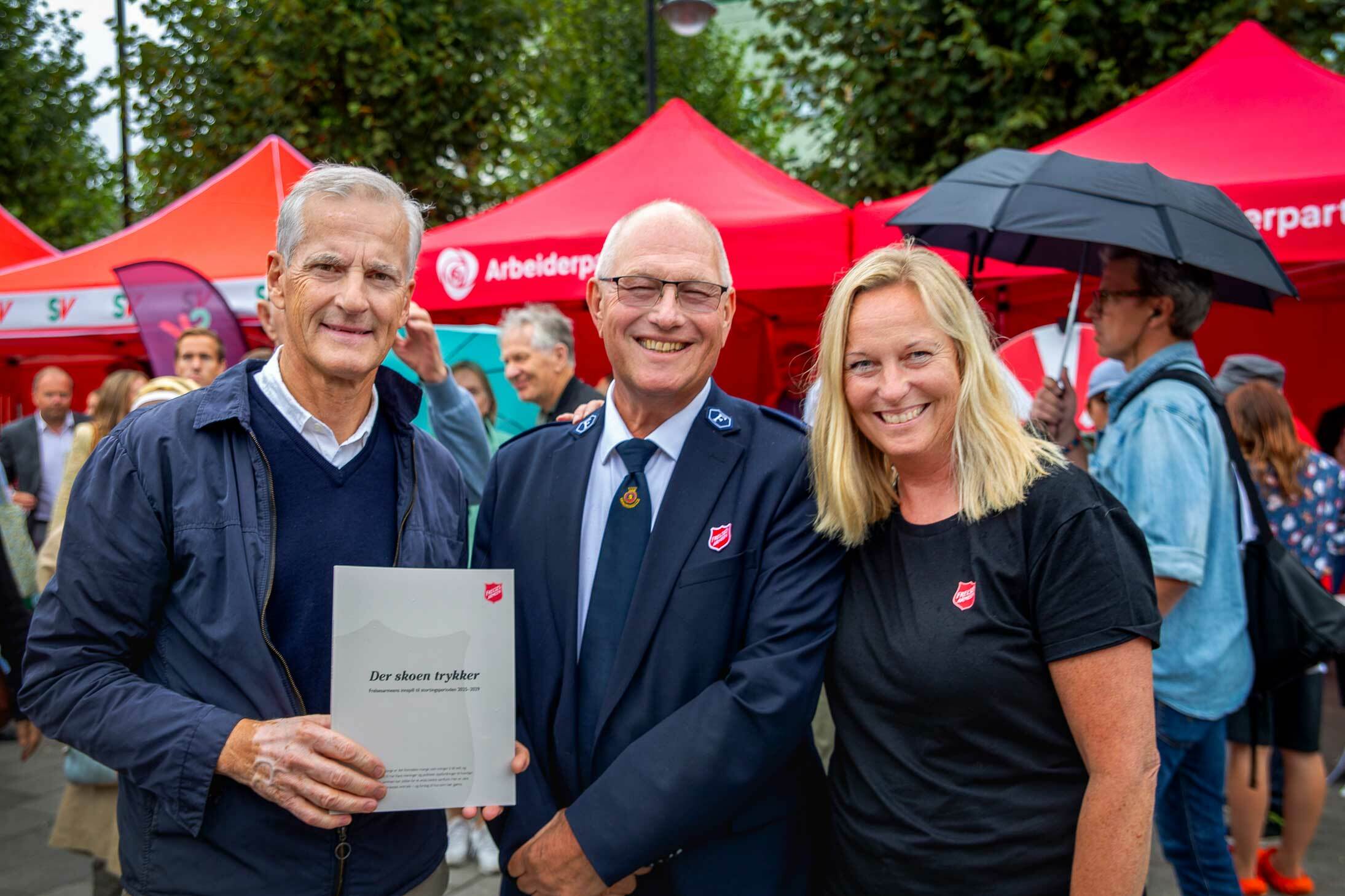Tre menn og en kvinne står foran Arbeiderpartiets røde valgkamptelt. To av dem har Frelsesarmeens skjold på brystet