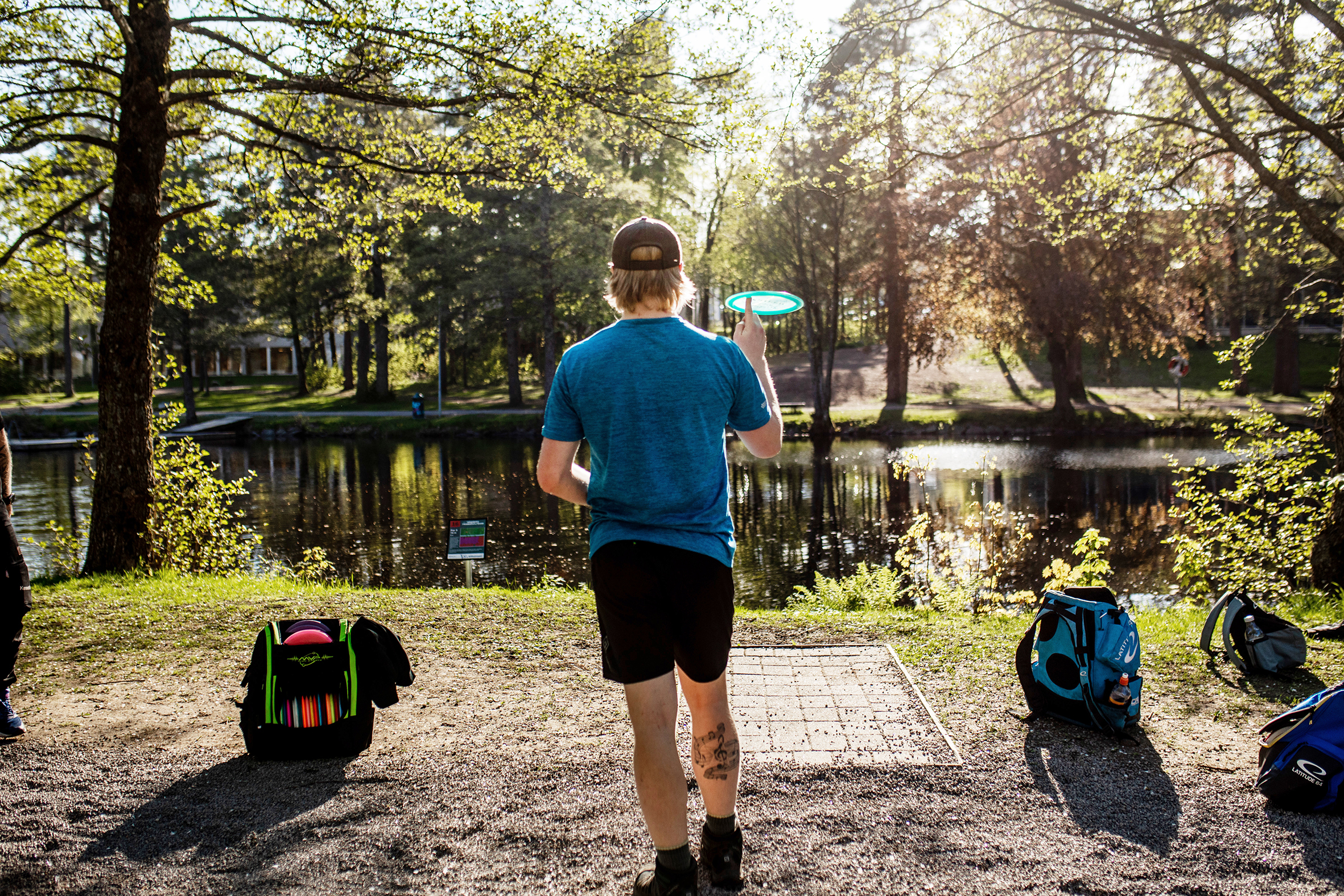 En av gutta sikter seg inn på ett nett på andre siden av dammen