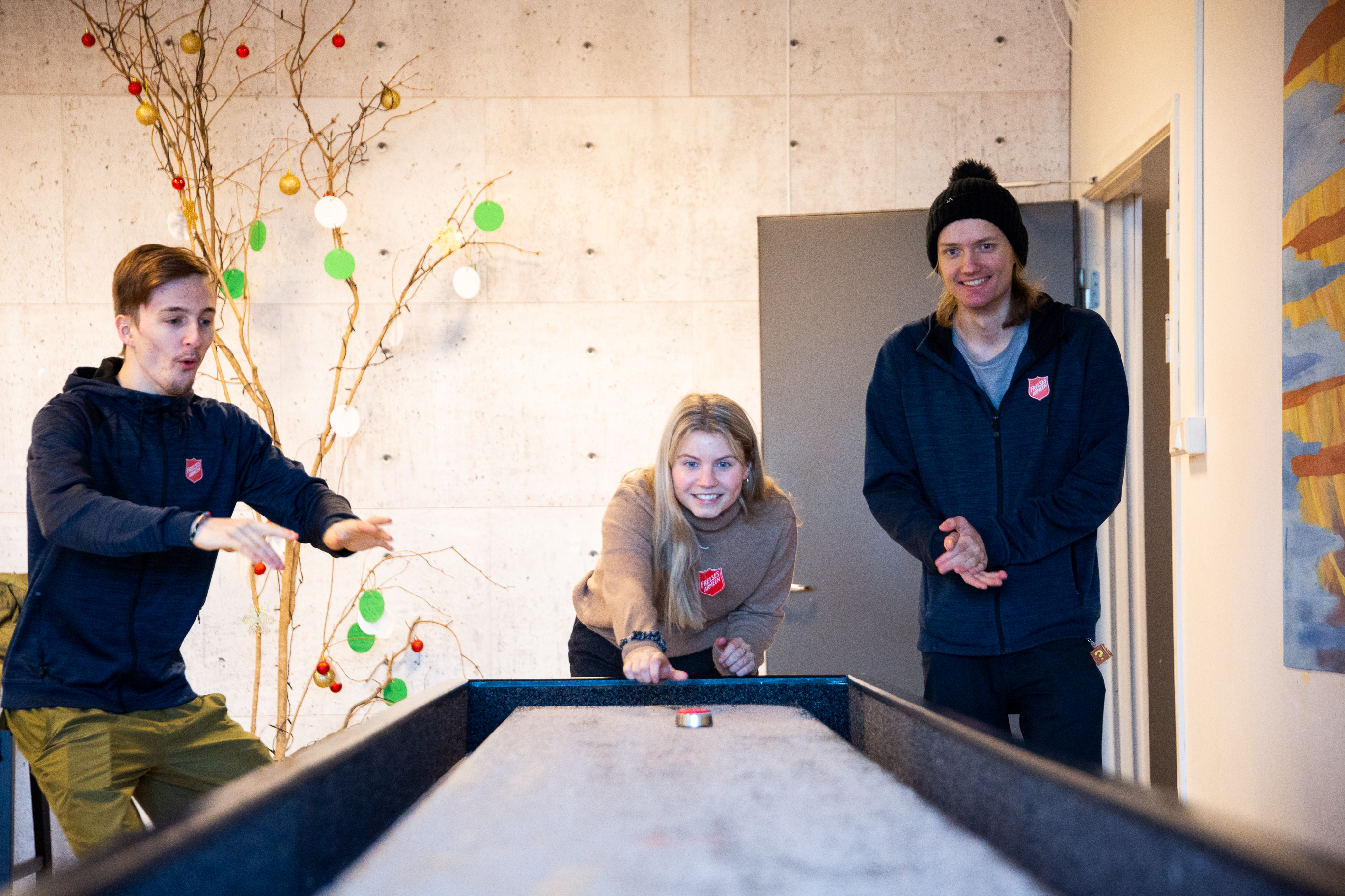 Tre av ungdommene fra Dynamo teamet spiller shuffelboard.