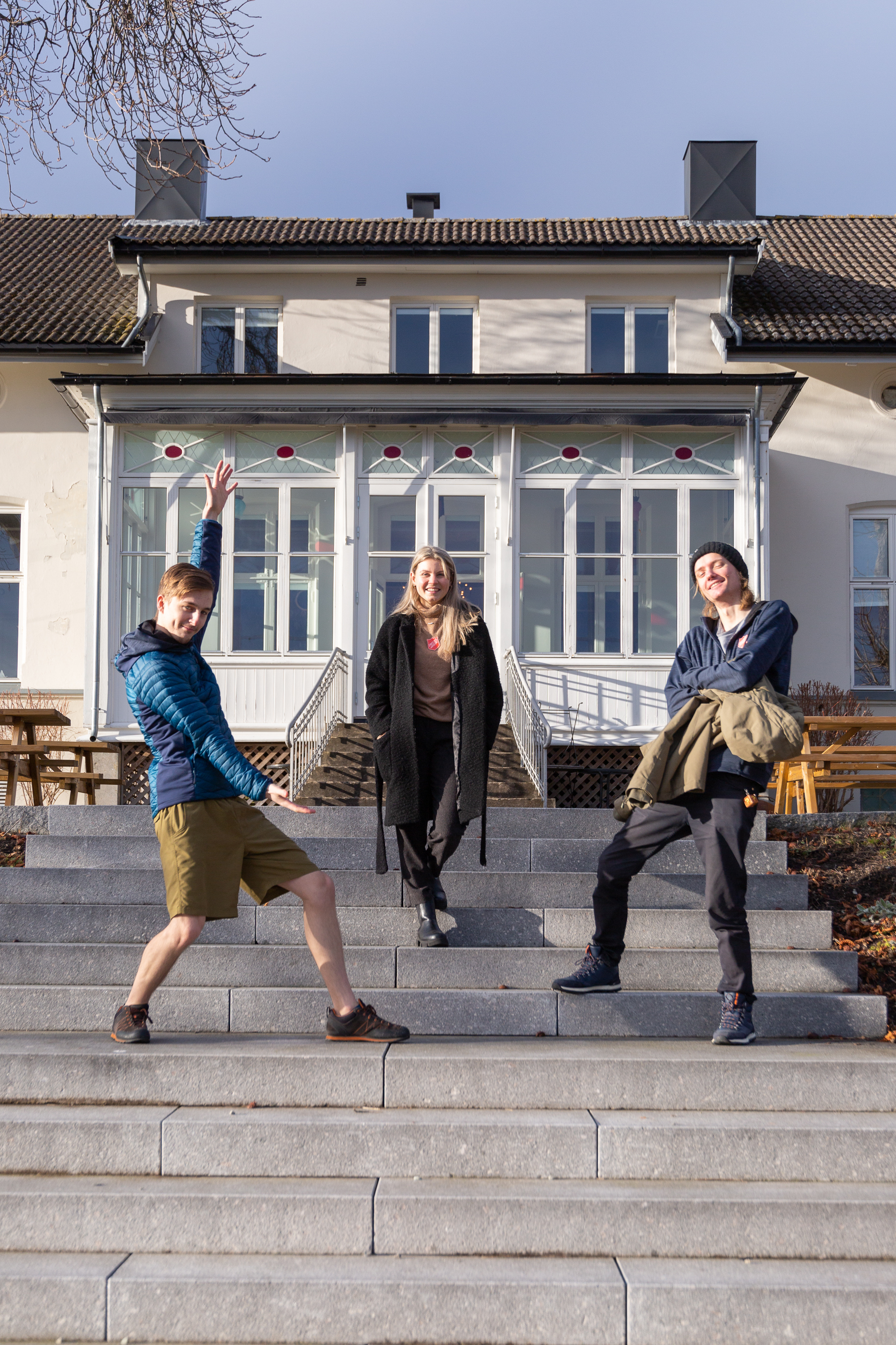 Dynamo gjengen og teamleder sitter smilende på trappen på Jeløy folkehøyskole