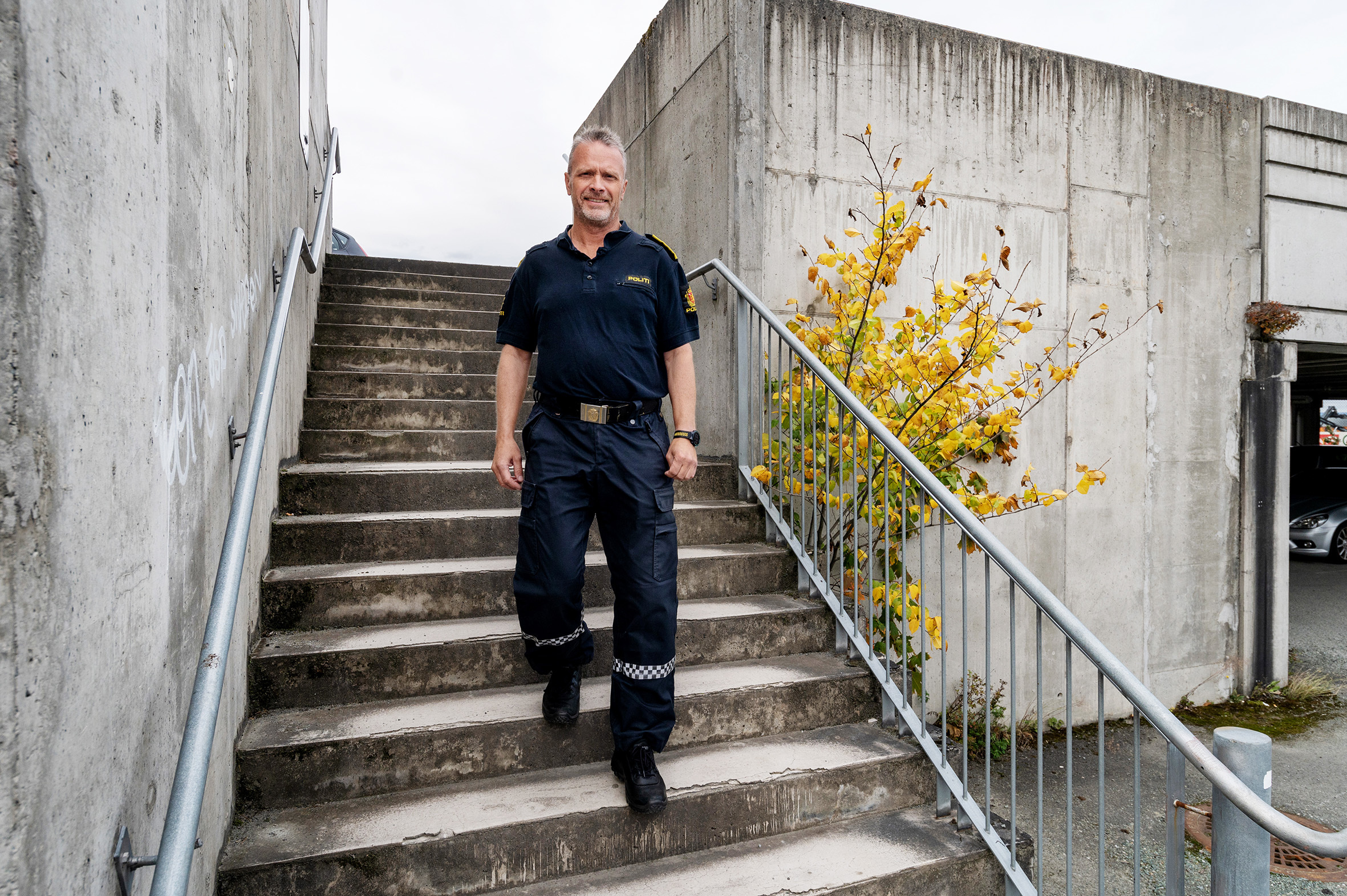 Ebbe Kimo går nedover en trapp iført politi uniform