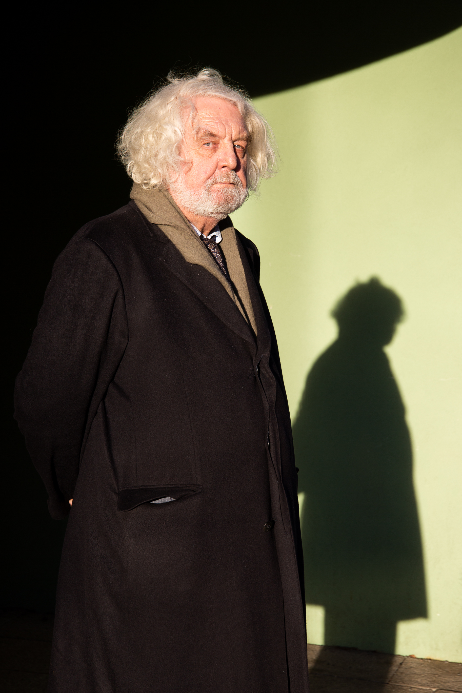 Edvard ser inn kameraet i ført en lang mørk frakk.