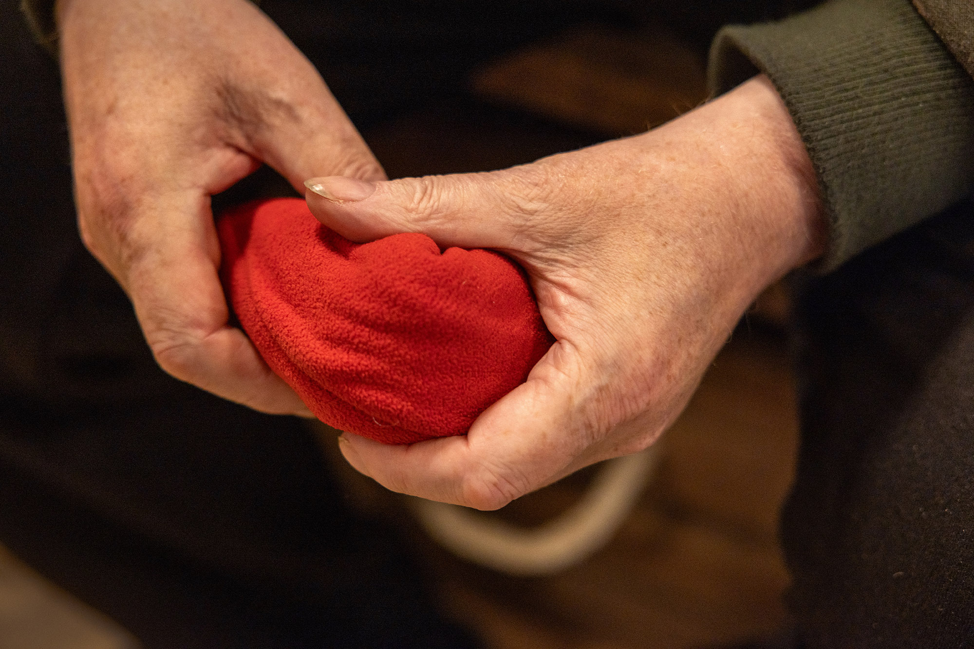 Foto: Gamle hender som holder en lue i hånden.