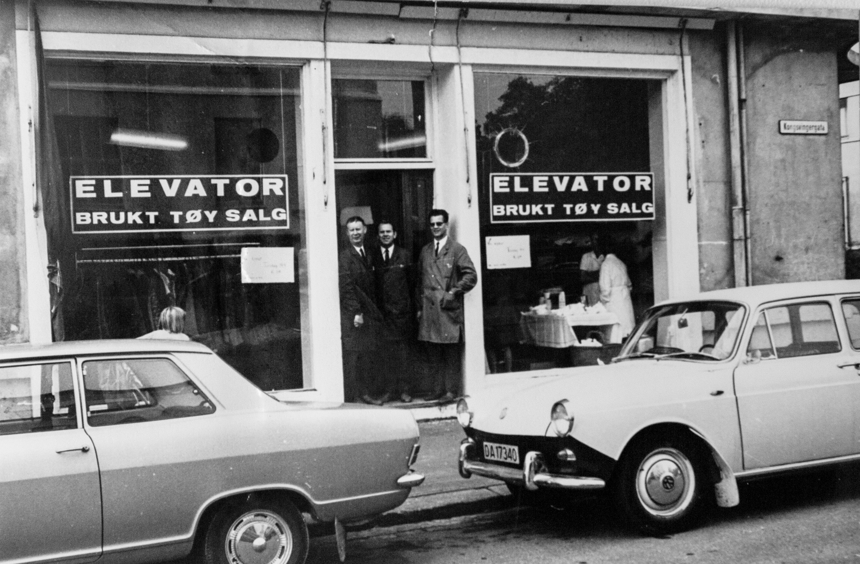 På dette sort/hvitt bildet fra 1968 står offiserene Strømmen, Rekdal og Fjelde utenfor Elevators brukttøyutsalg i Grimstadgata på Sagene/Bjølsen. (Foto: Frelsesarmeens arkiv)