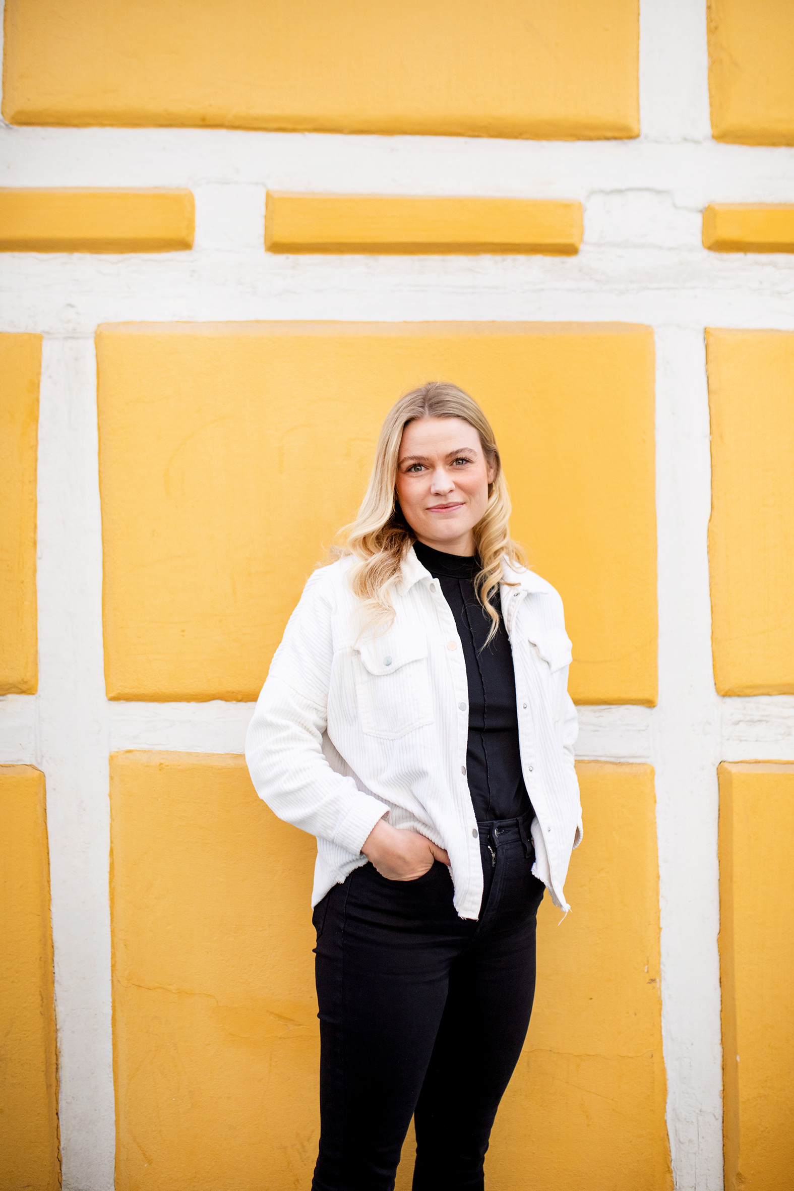 Elise Kruse foran en gul vegg
