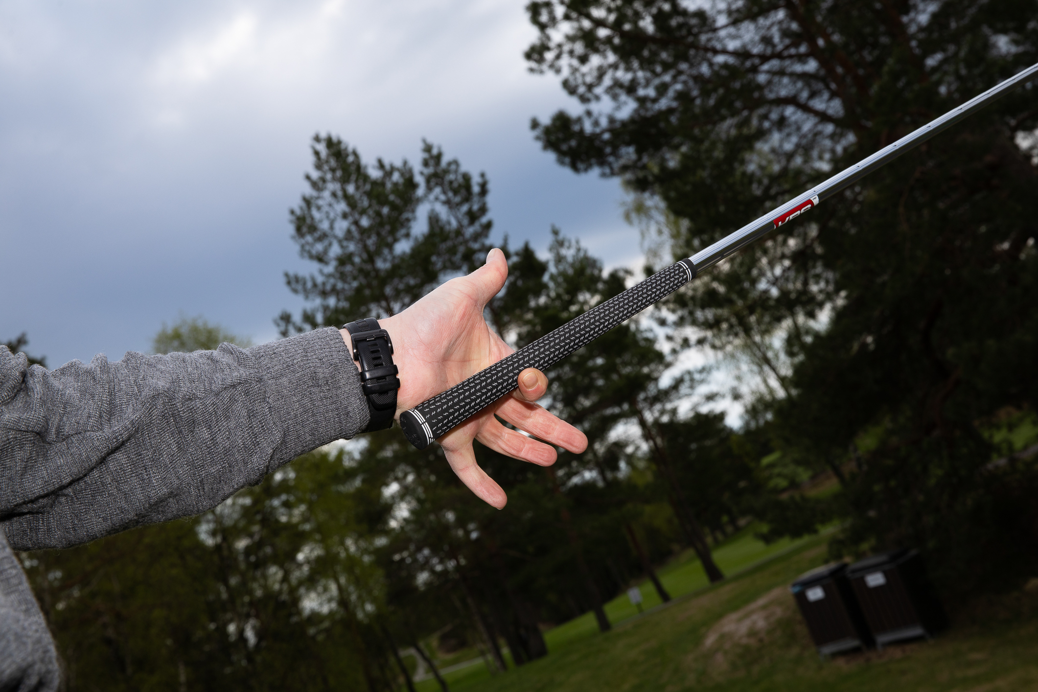 Foto: To bilder etter hverandre. Det først viser en smilende mann med caps som kjører en golfbil. Bildet er tatt innefra, slik at en ser ut på grusveien gjennom ruta. Det andre bildet viser en hånd som holder opp en golfkølle med et spesielt grep.