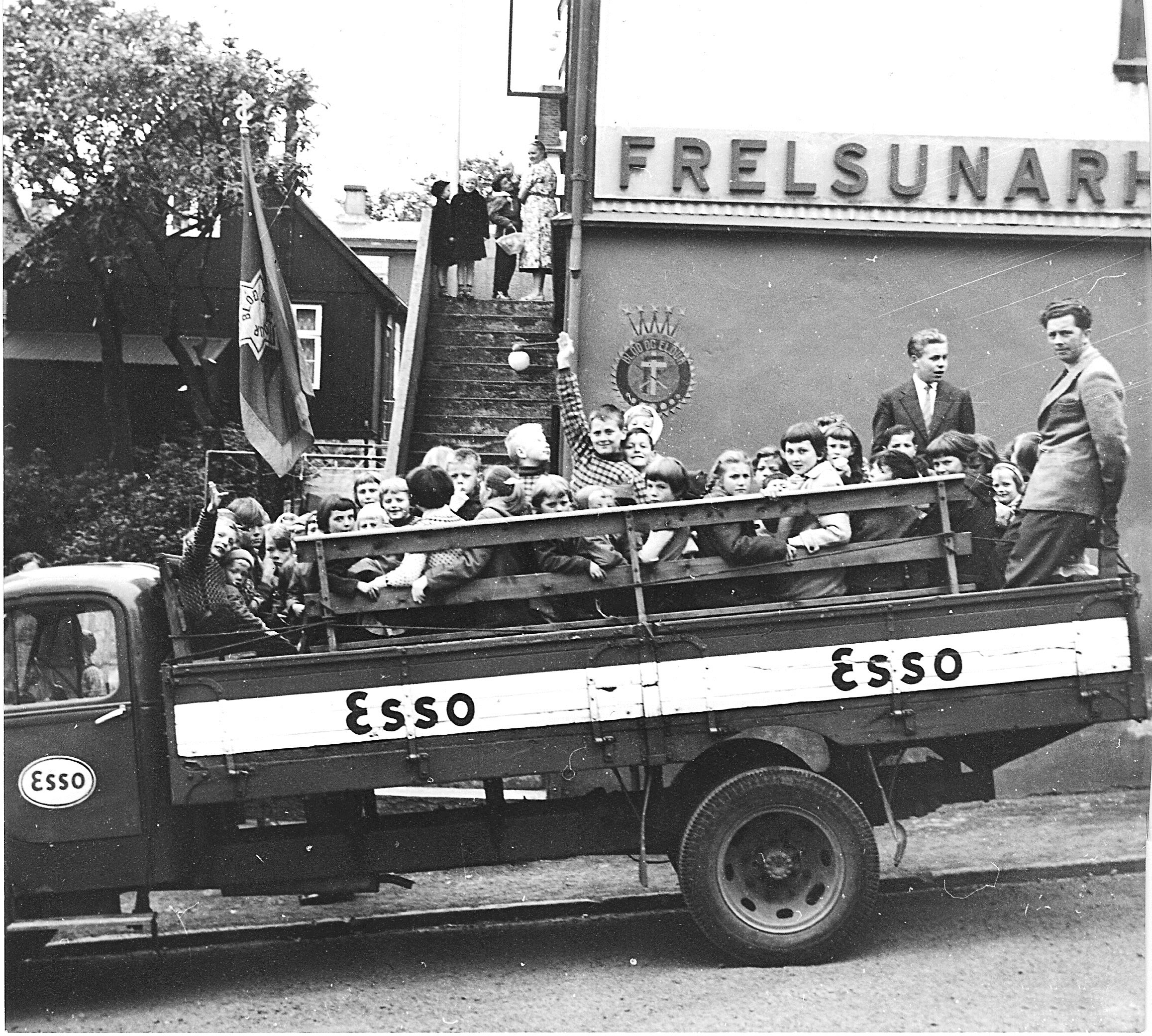 To svart-hvitt foto: Det første er av gammelt hus med torvtak. Utenfor står mange mennesker og lytter til noen som taler. Den andre er av en gjeng barn- og unge sitte bakpå et åpent lasteplan.