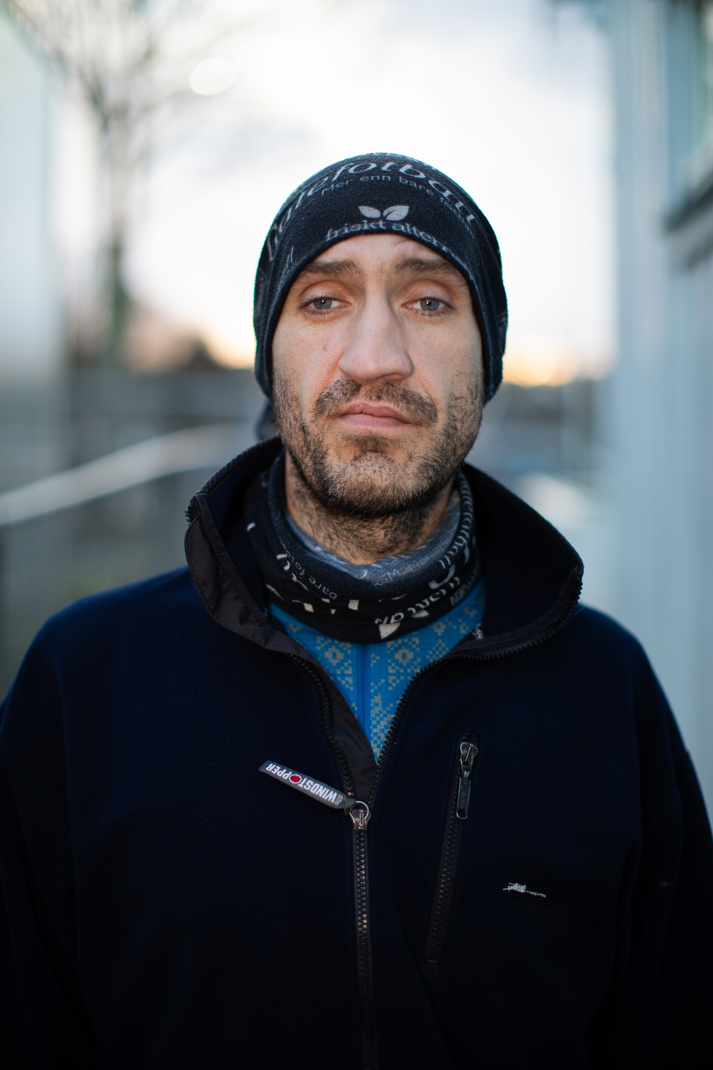 Foto: Mann med blå lue og vinterjakke ser i kamera. Han har et tidligere brudd i nesen.