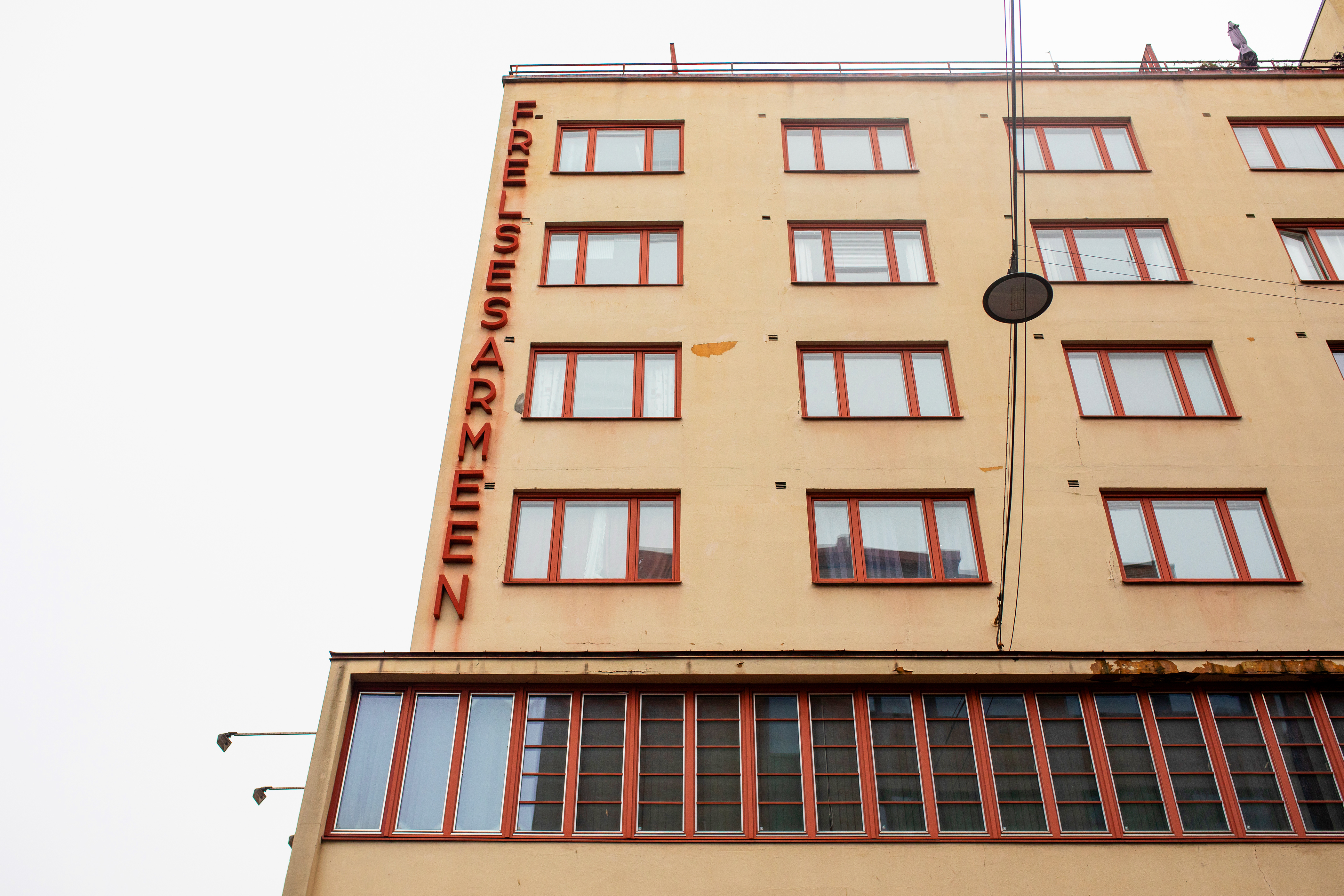 Bildet av Frelsesarmeens bo tilbud FaBo. Et 50-60 talls blokk med gul murpuss og rød vinduskarmer.