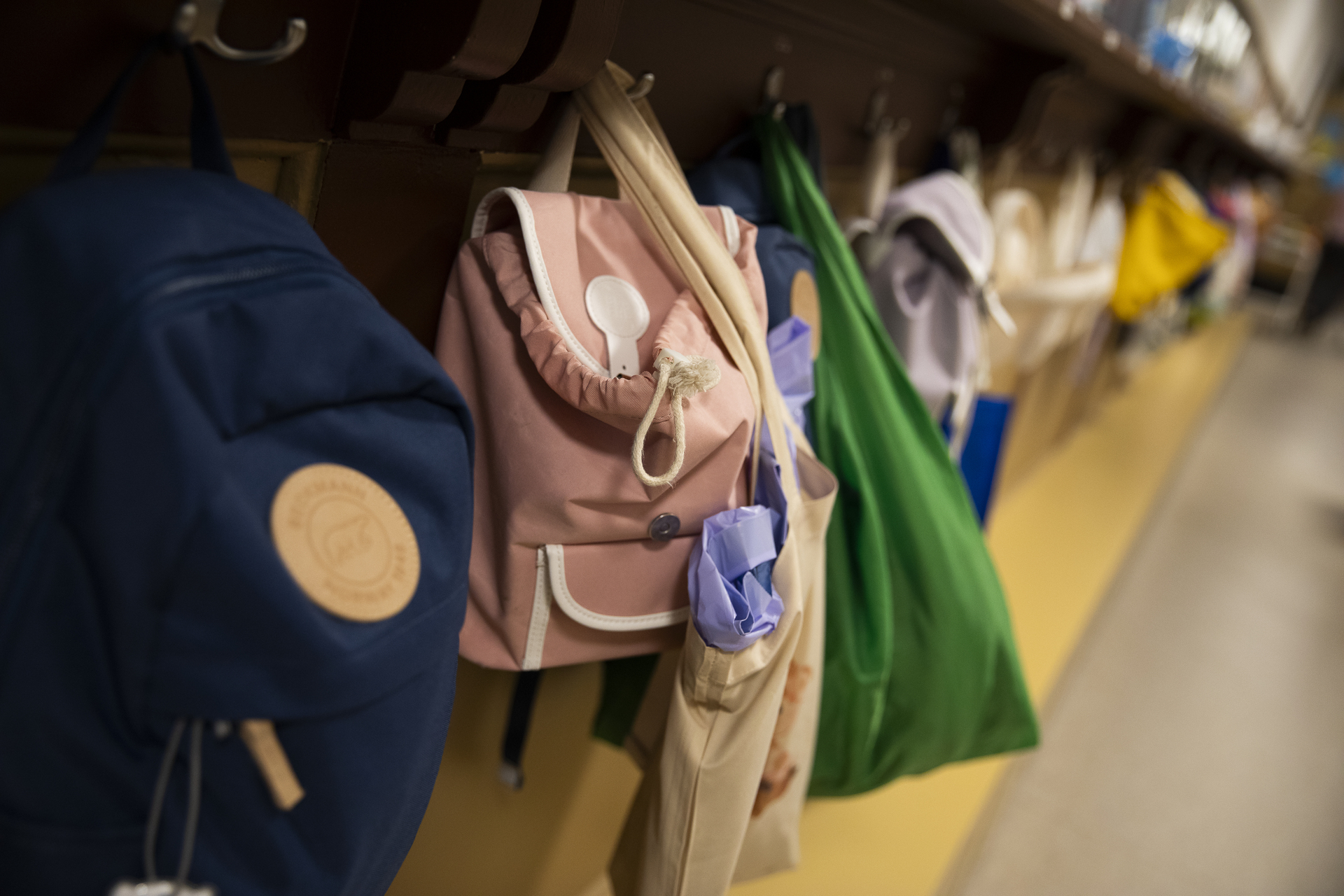 Foto: Knaggrekke fra garderobe med sekker og klær hengende bortover.