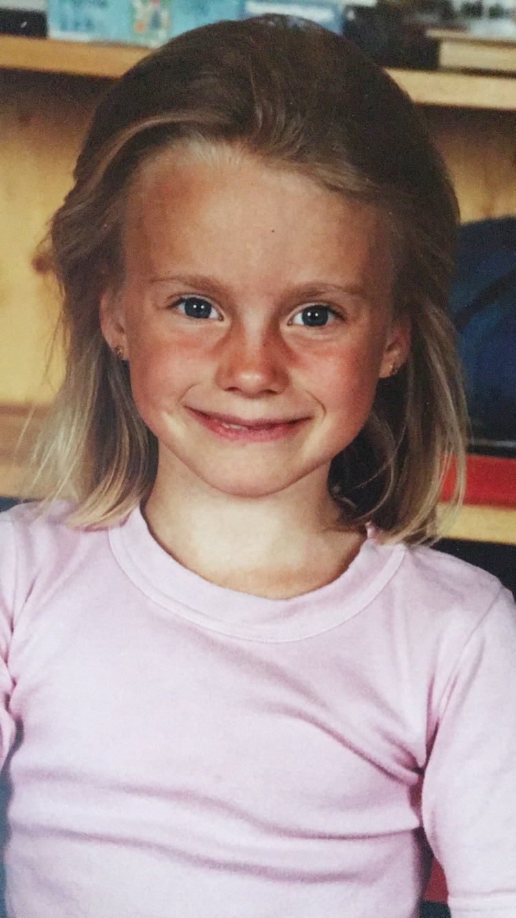 Eldre skolefoto av en liten jente med rosa genser.