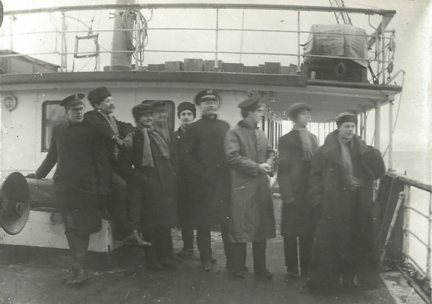 Foto: Gammelt fsvart-hvitt-bilde av menn en instrumenter som står foran på dekk et skip.