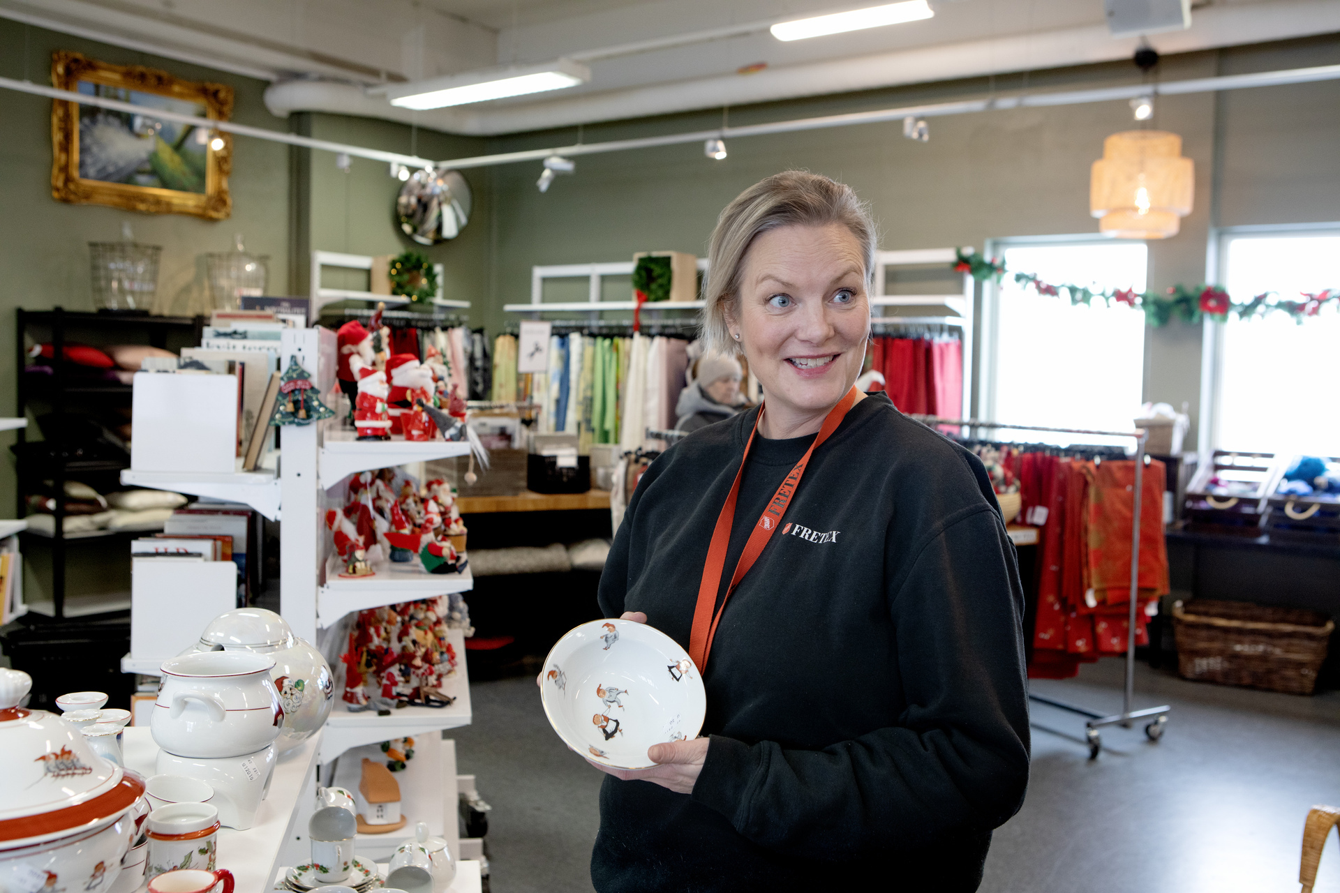 Kvinne viser fram en tallerken i en butikk.