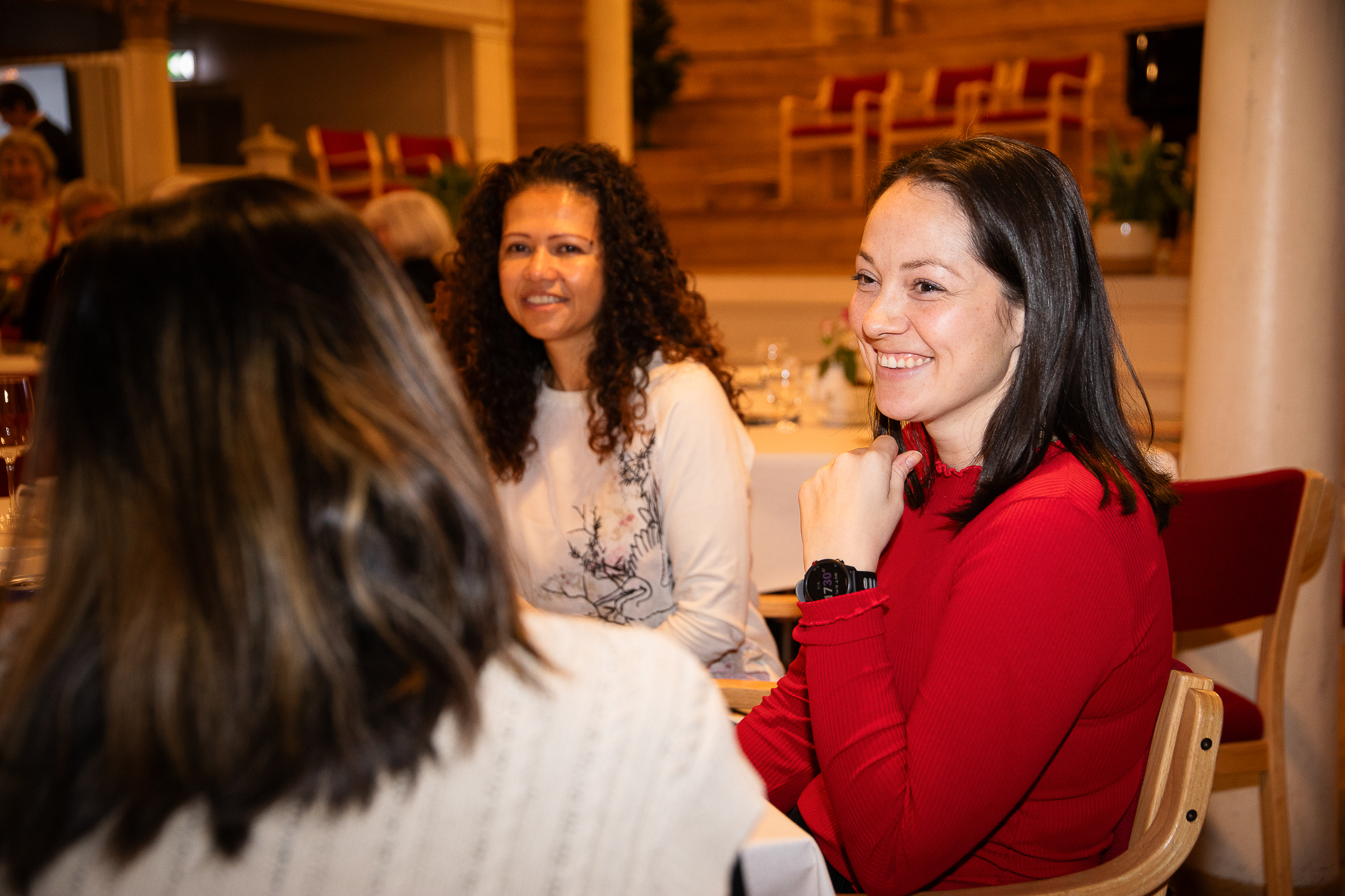 Kvinne på enden av et bord fra Frelsesarmeen snakker med to andre kvinner ved et bord.