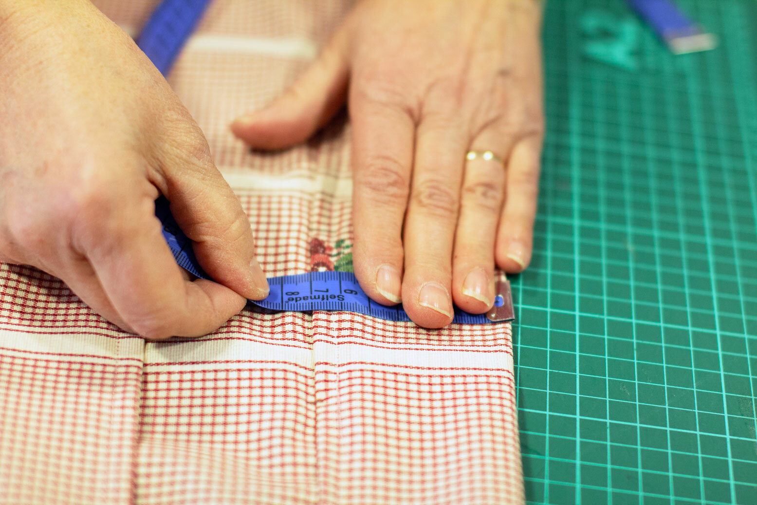 Foto: Hender som syr, her måles det centimeter med et målebånd.