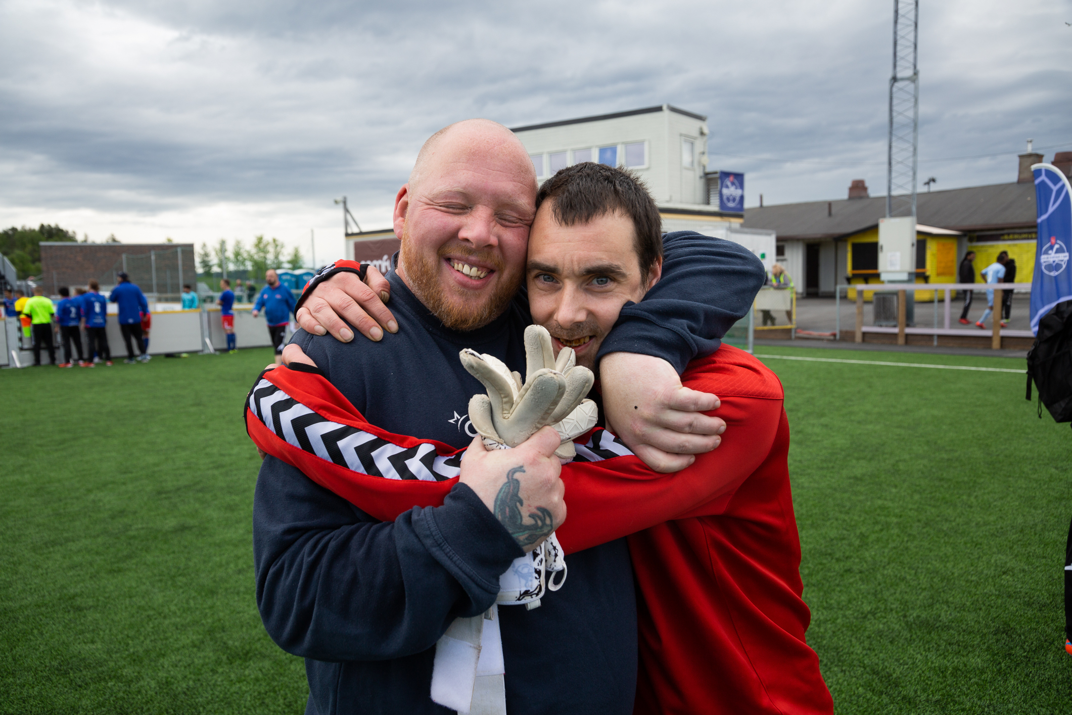 To fotballspillere gir hverandre en klem på banen