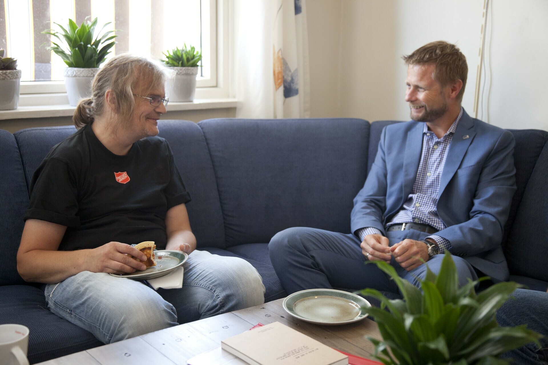 Foto: To bilder etter hverandre, der det første er med Erna Solberg sammen med en ansatt og en soldat på Gatehospitalet. På det andre bildet sitter Bent Høie i en sofa med en mann i T-skjorte fra Frelsesarmeen.