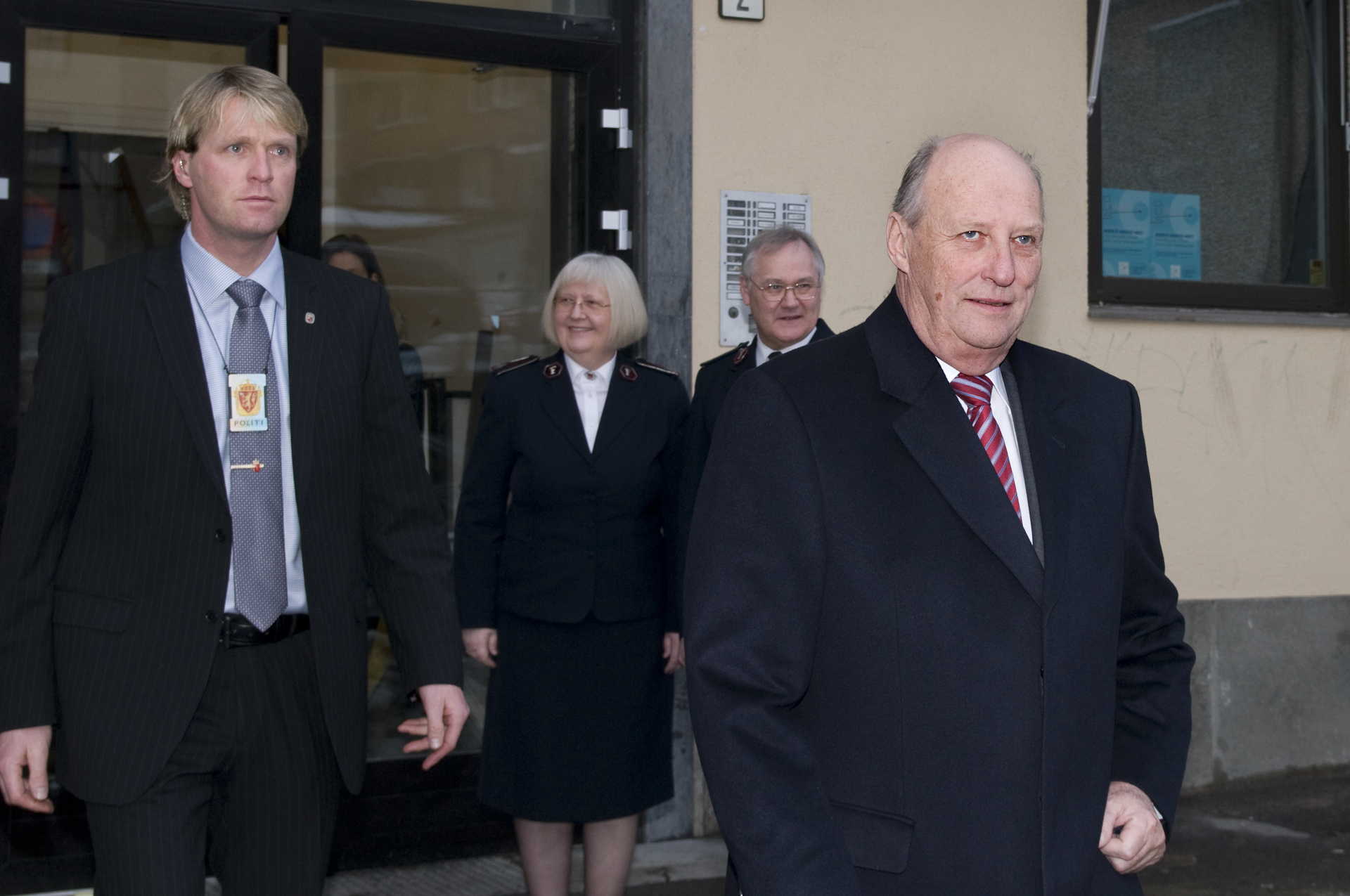 Foto: Kongen følges ut av en gul murbygning.