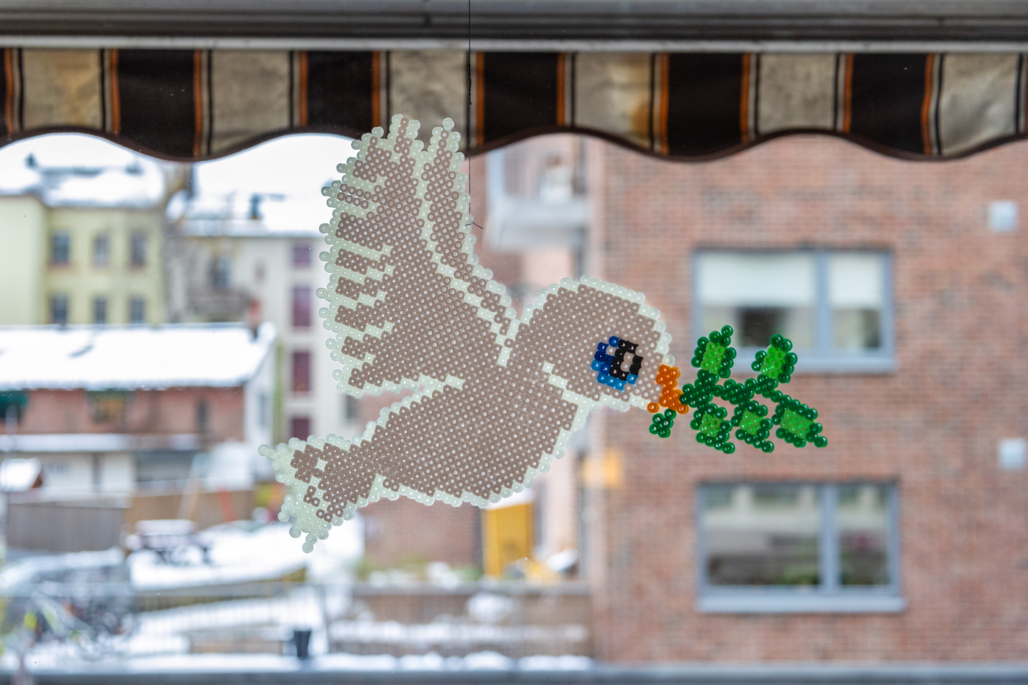 Middelaldrende mann ligger på en sykeseng og leser i en bok. På nattbordet står en rosa bamse og en vase med  røde roser