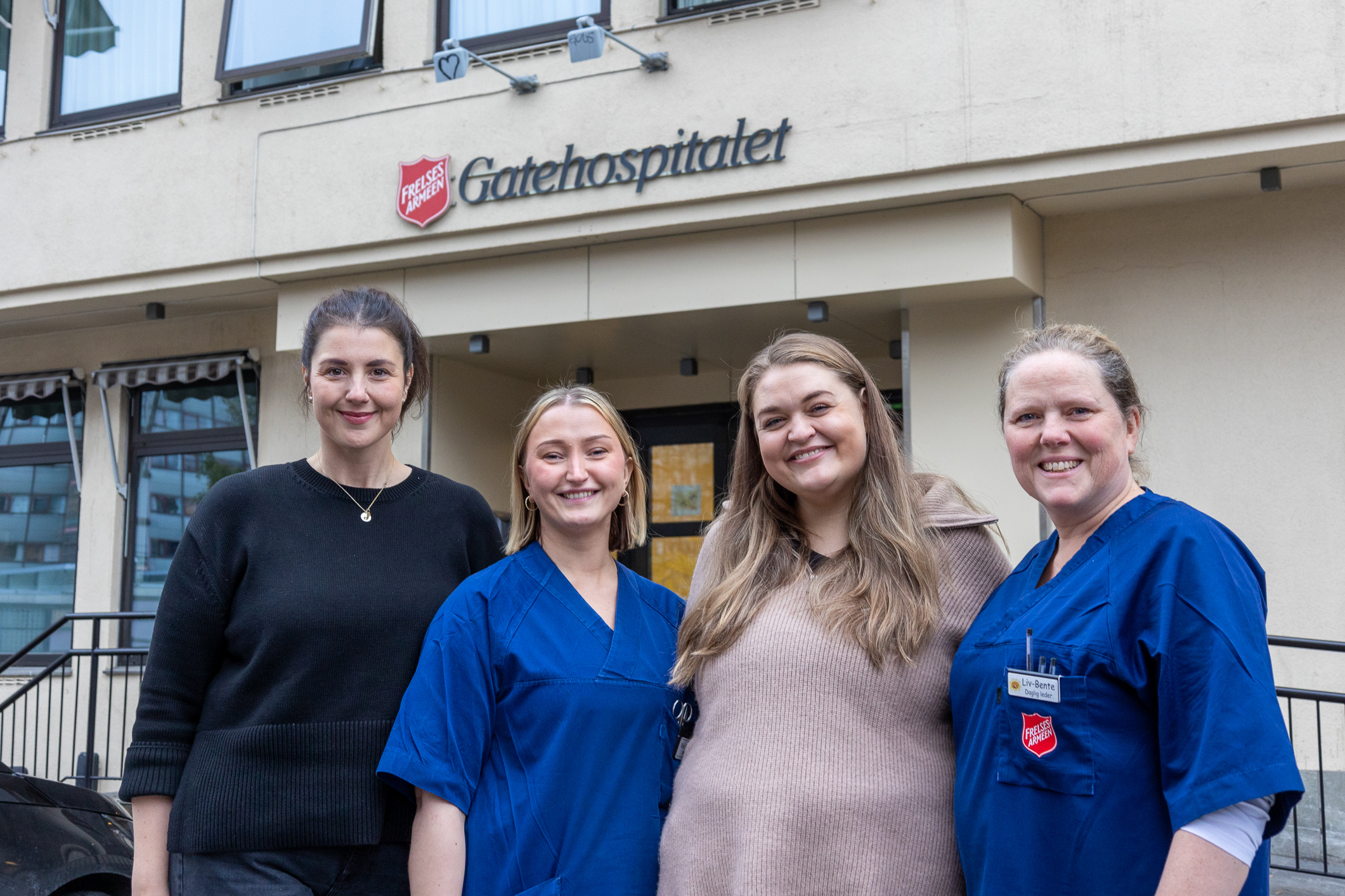 En gruppe på fire sykepleiere utenfor utgangen til et omsorgsbygg.