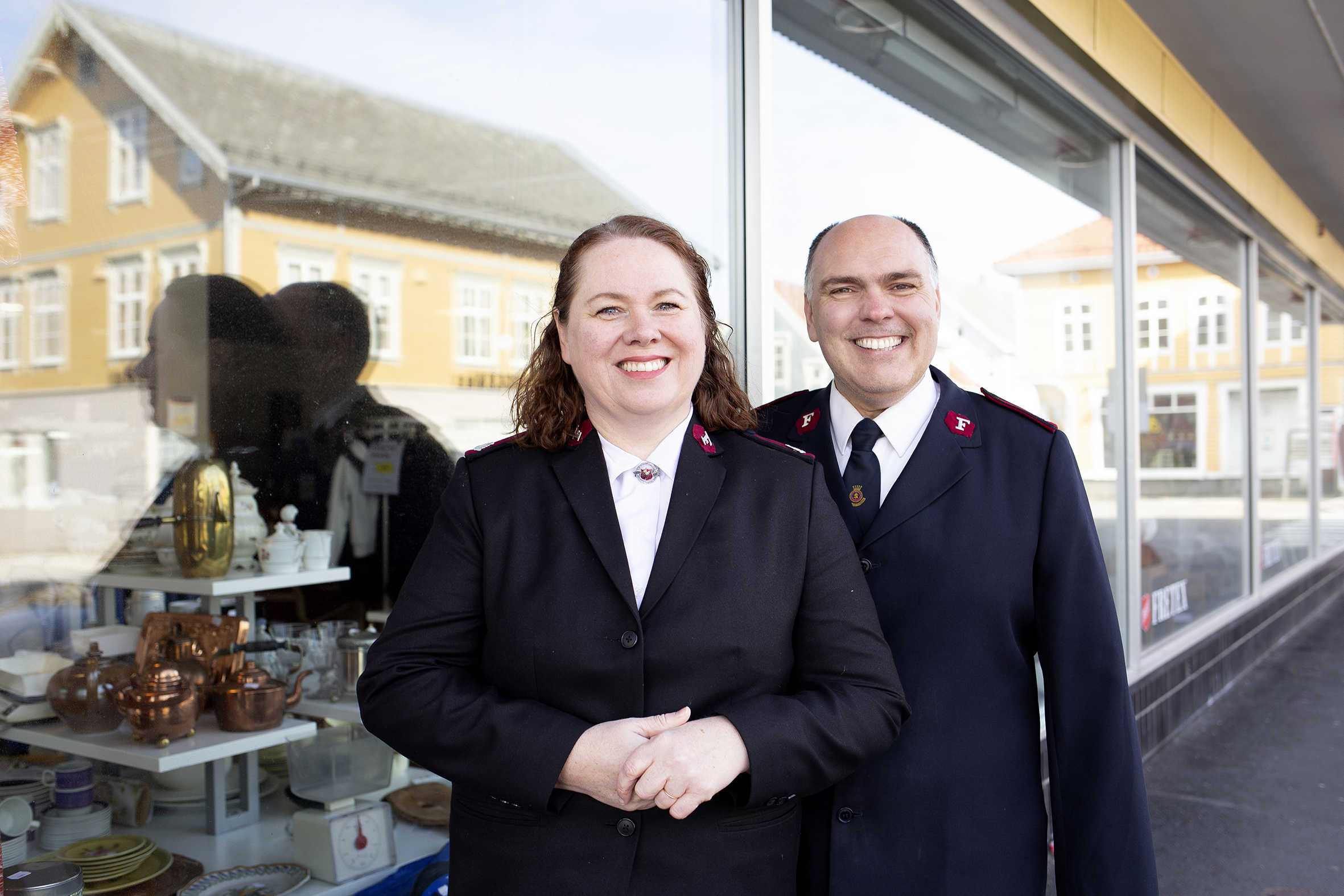 Ester og Walter i uniform foran den nye Fretex-butikken som drives av 40 flinke frivillige.