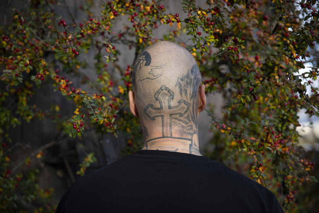 Bakhodet på en skallet mann med tatovert et kors i nakken.