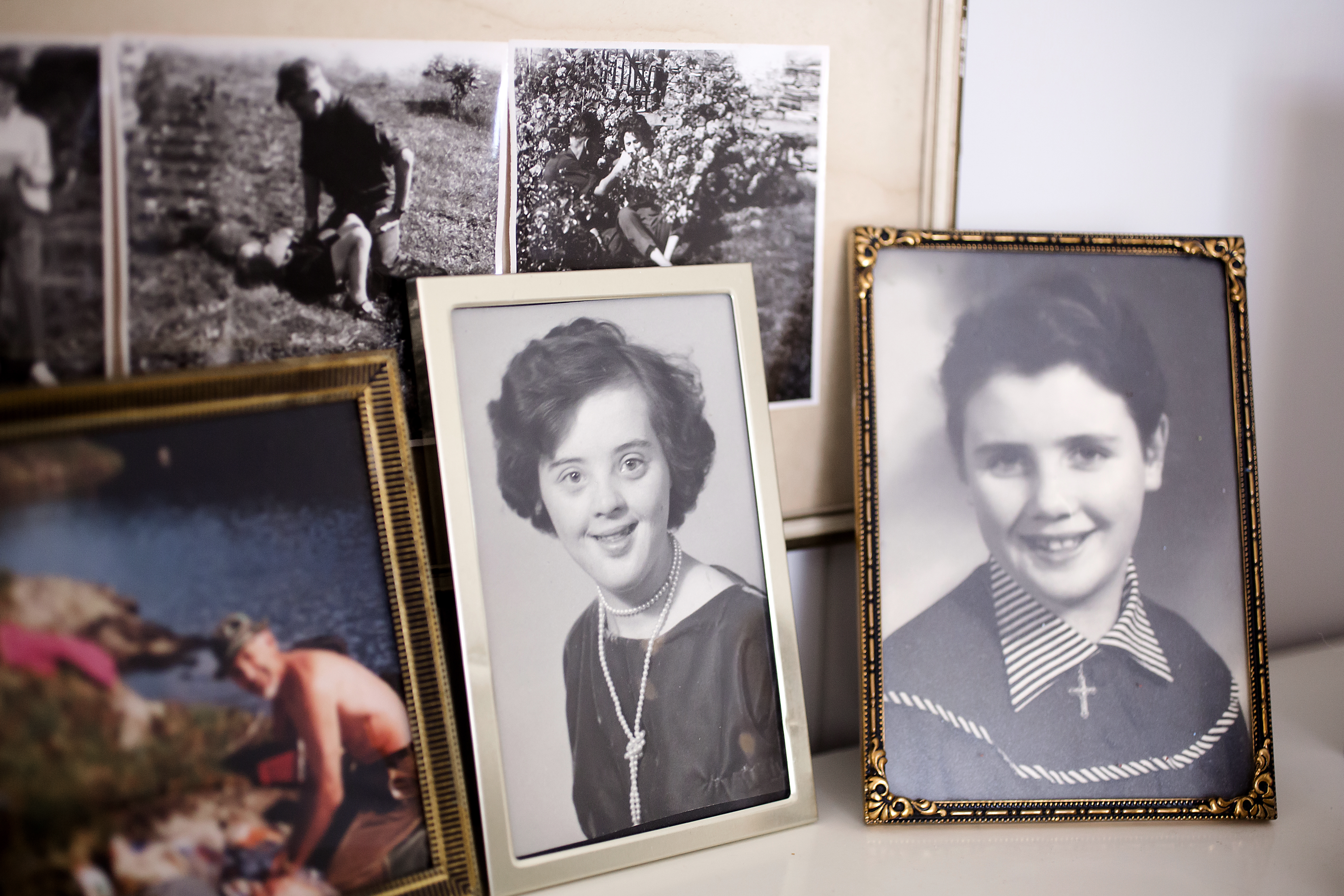 Bildet viser en hylle med familiebilder. Vi ser barnebilder av Haldis og søsteren, Sigbjørg.