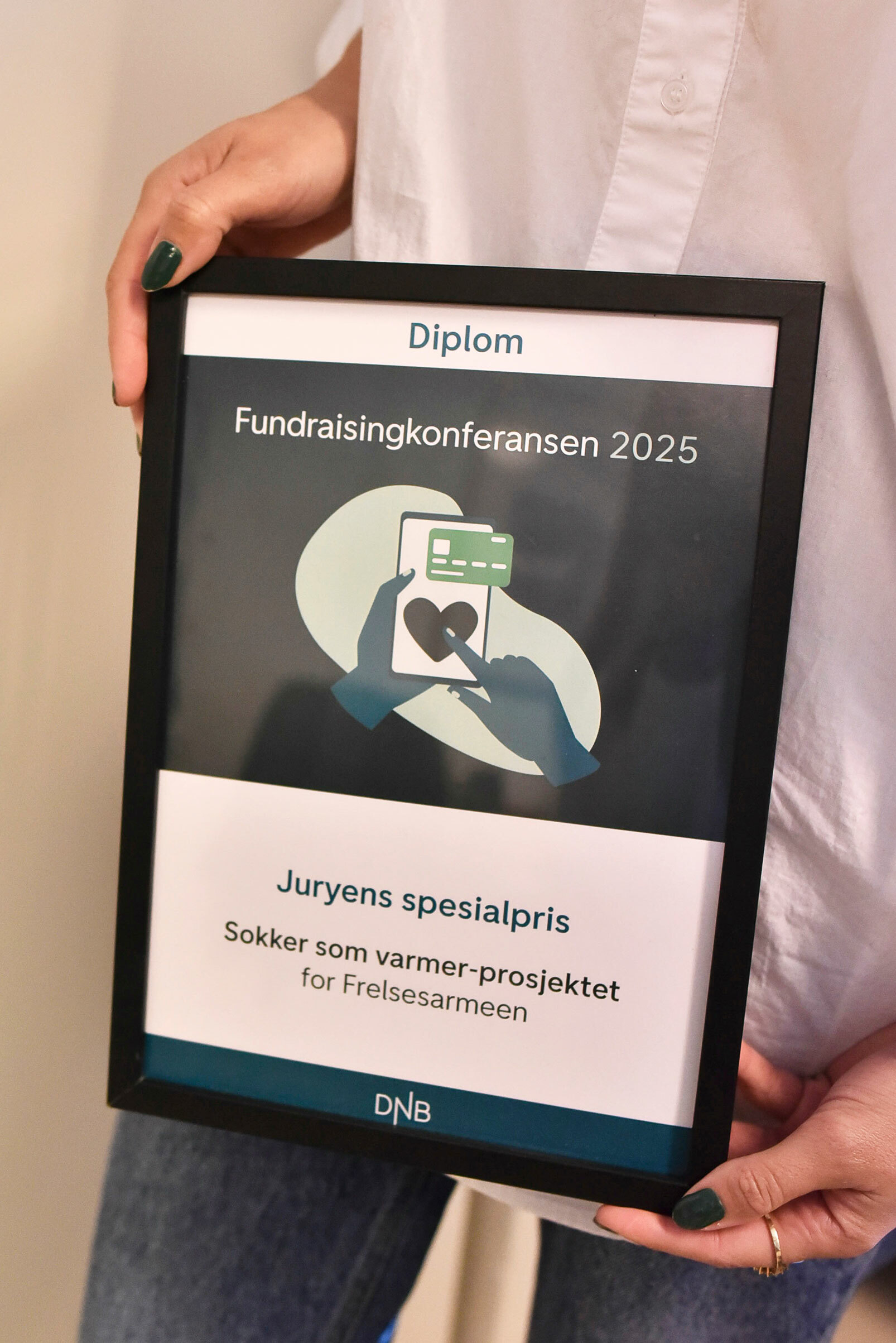 Foto: Kvinnehender holder opp et diplom.